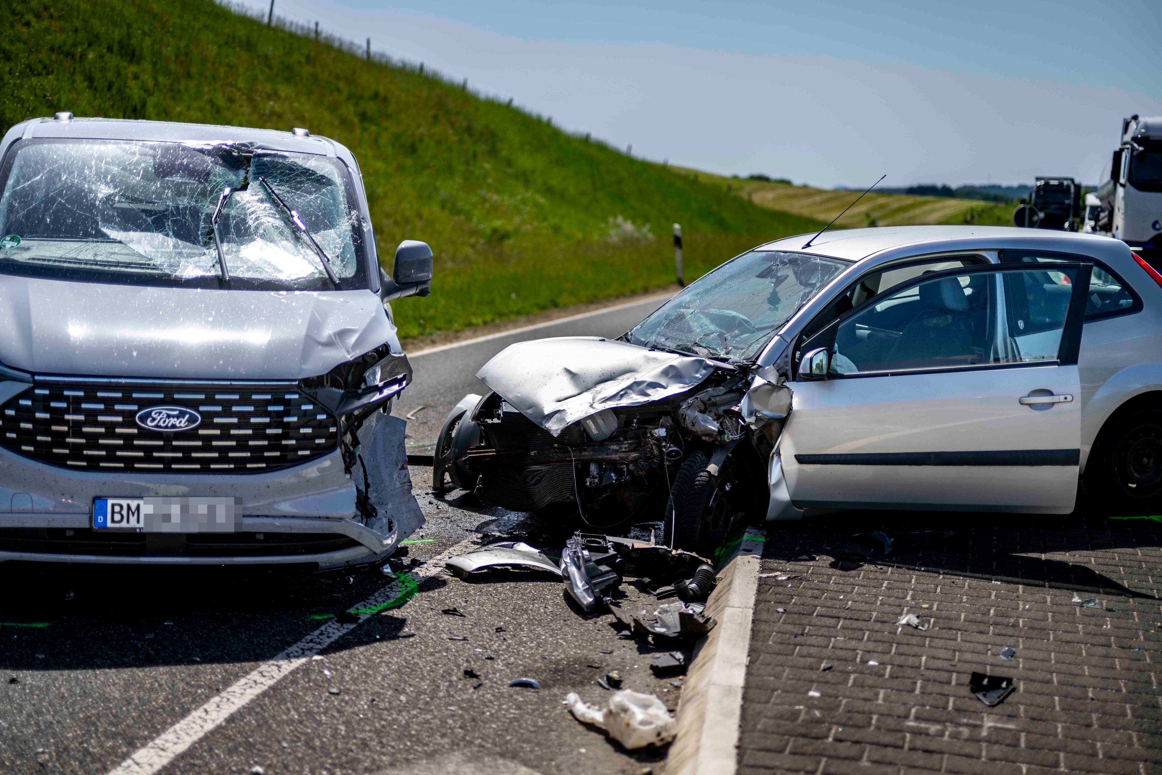 Das Bild zeigt die zwei stark beschädigten Autos nach dem Unfall auf der L115.
