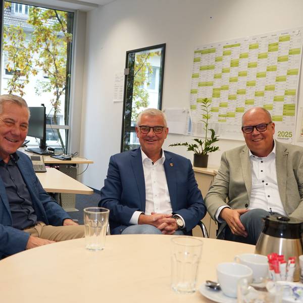 Auf dem Foto sind drei Männer zu sehen.