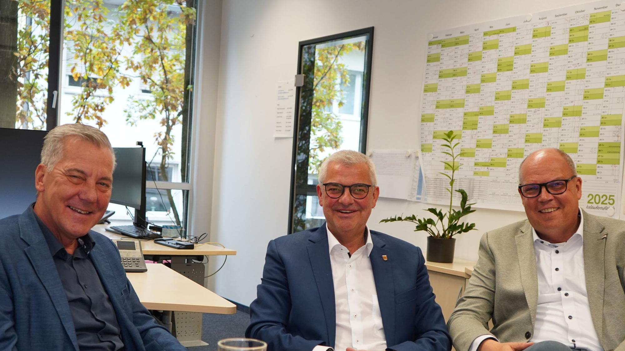Auf dem Foto sind drei Männer zu sehen.