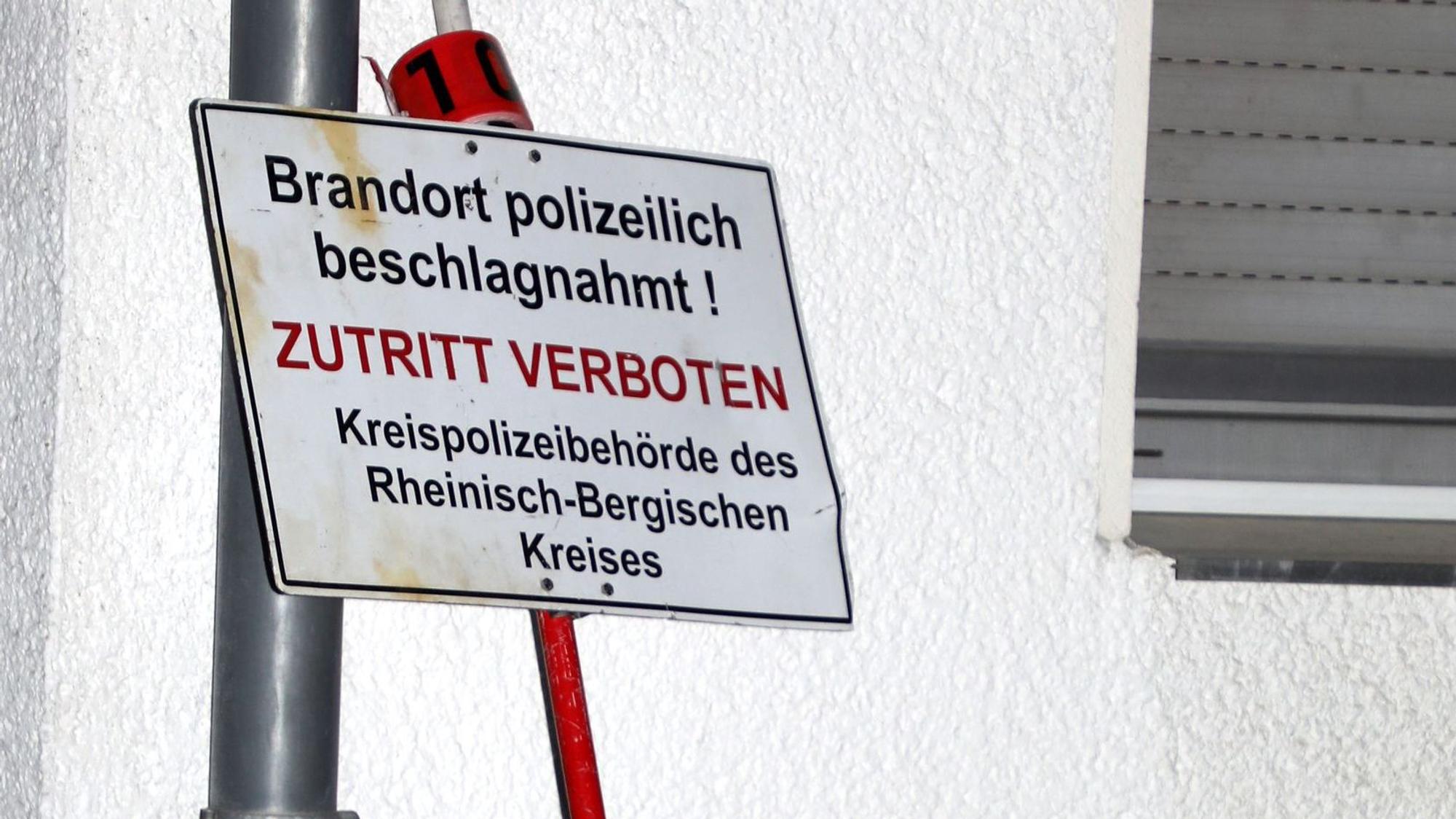 Ein Polizeischild lehnt an einem Mehr-Parteien-Haus in Bergisch Gladbach-Lustheide.