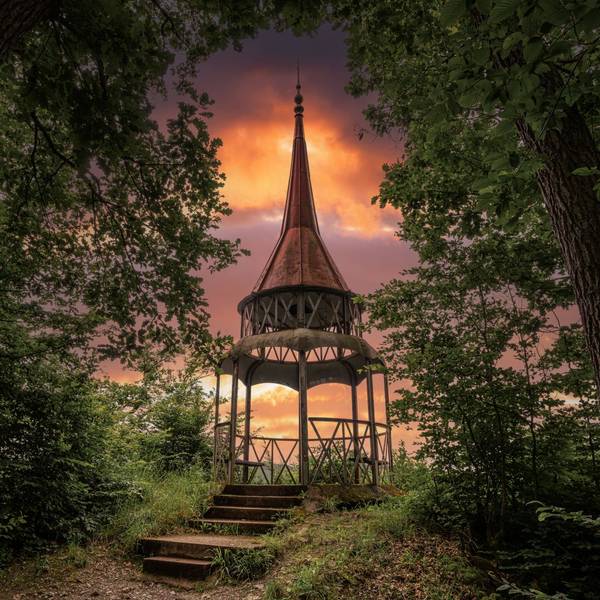 Der Hohenzollernzurm bei Bad Bertrich in der Eifel ist vor einem in spektakulären Orangetönen gefärbten Himmel zu sehen.