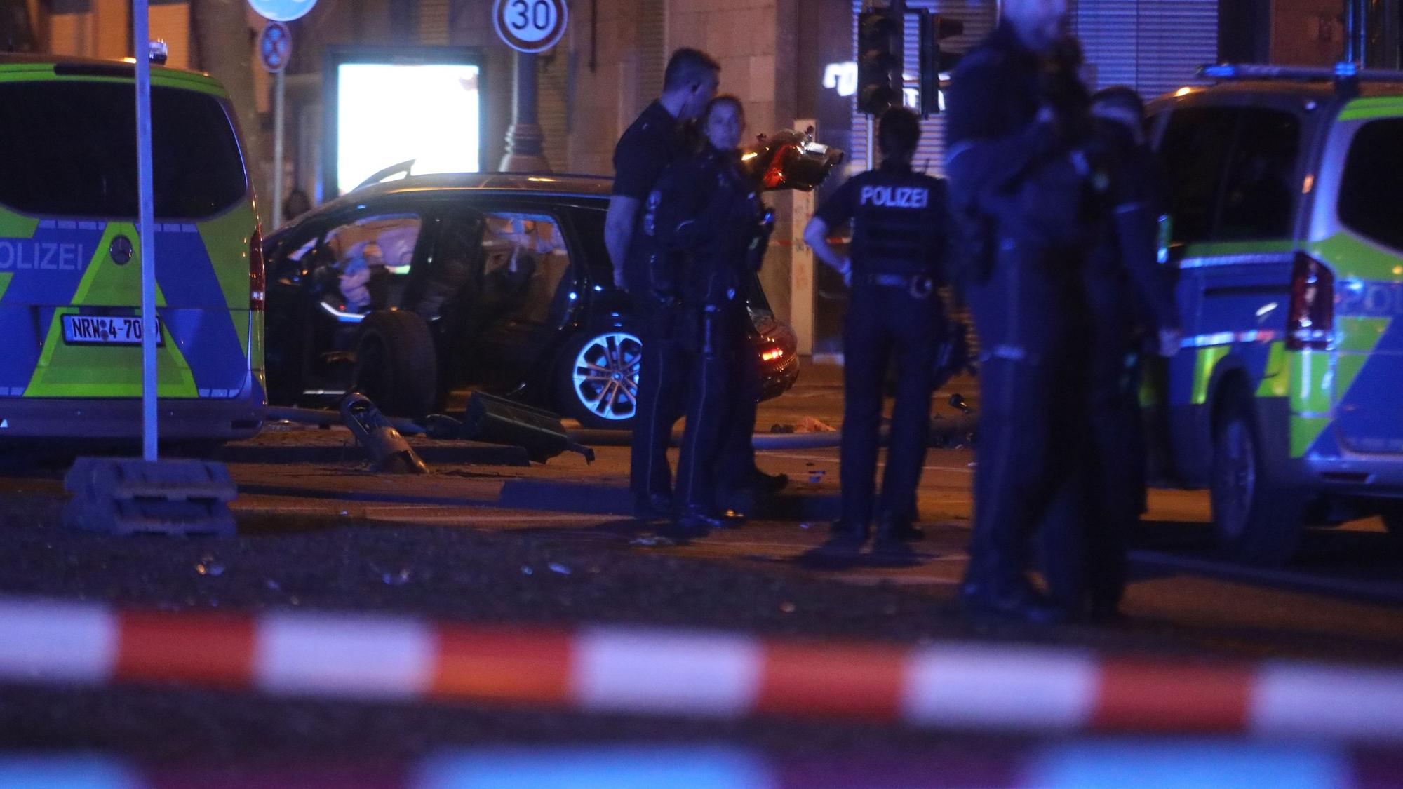 Die Polizei ist mit Kräften und Fahrzeugen auf einer Straße im Einsatz. Der Bereich ist mit Flatterband abgesperrt.