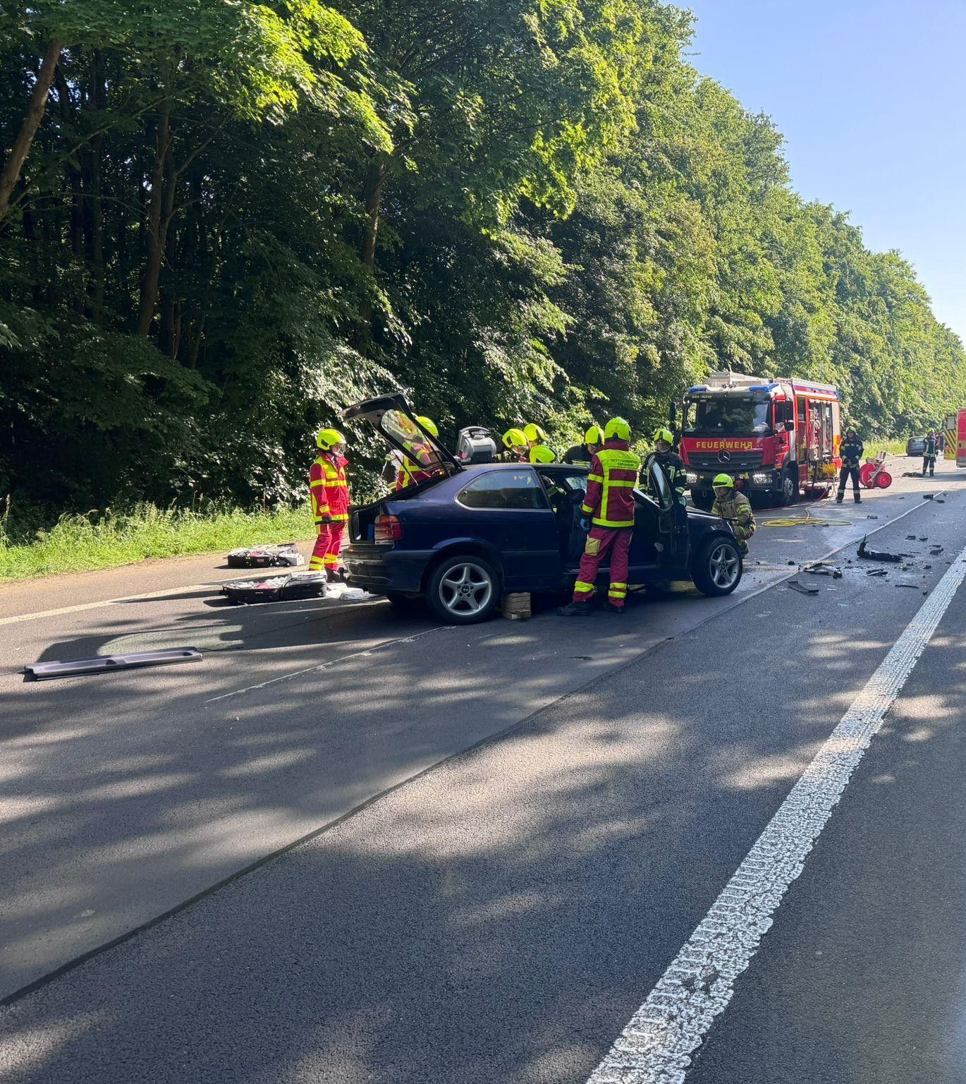 Das Bild zeigt Einsatzkräfte an einem Unfallwagen.