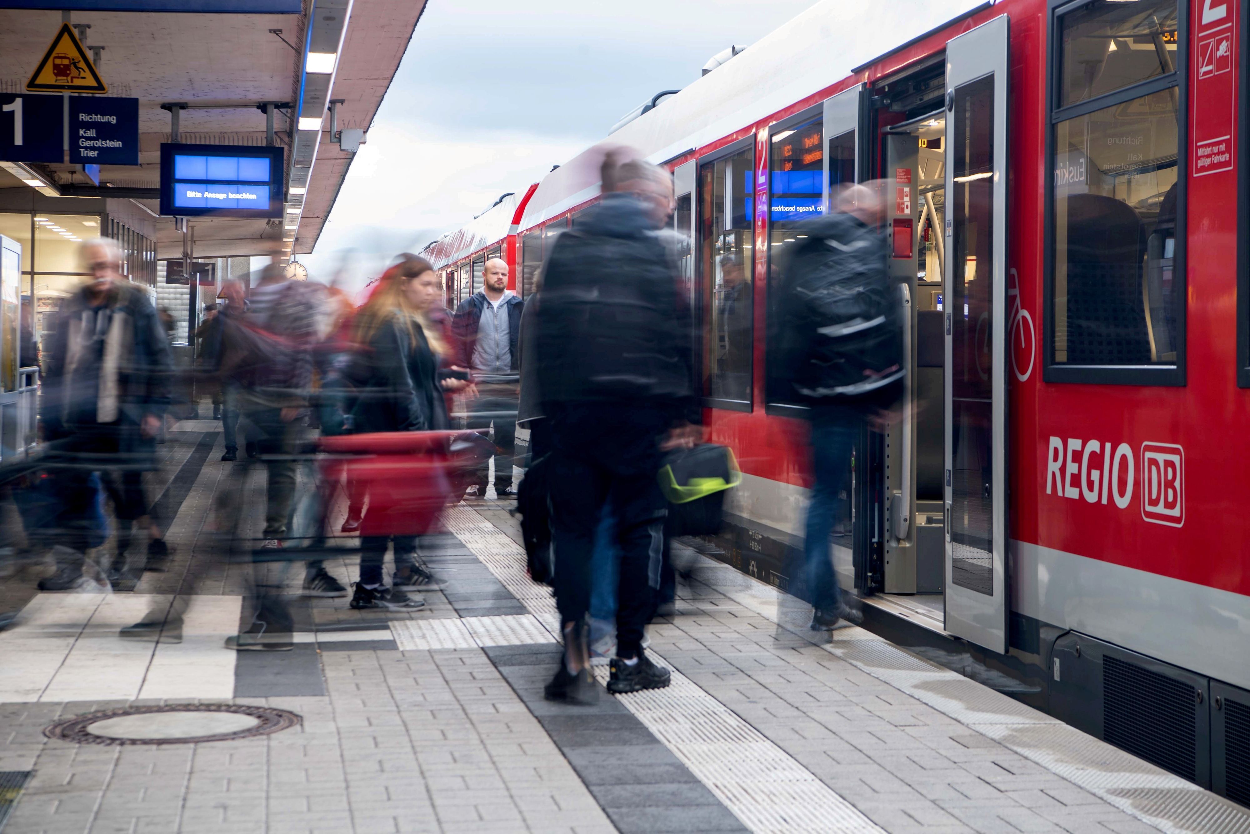 Ein Zug hält im Euskirchener Bahnhof. Die Menschen auf dem Bahnsteig sind verwischt zu sehen.