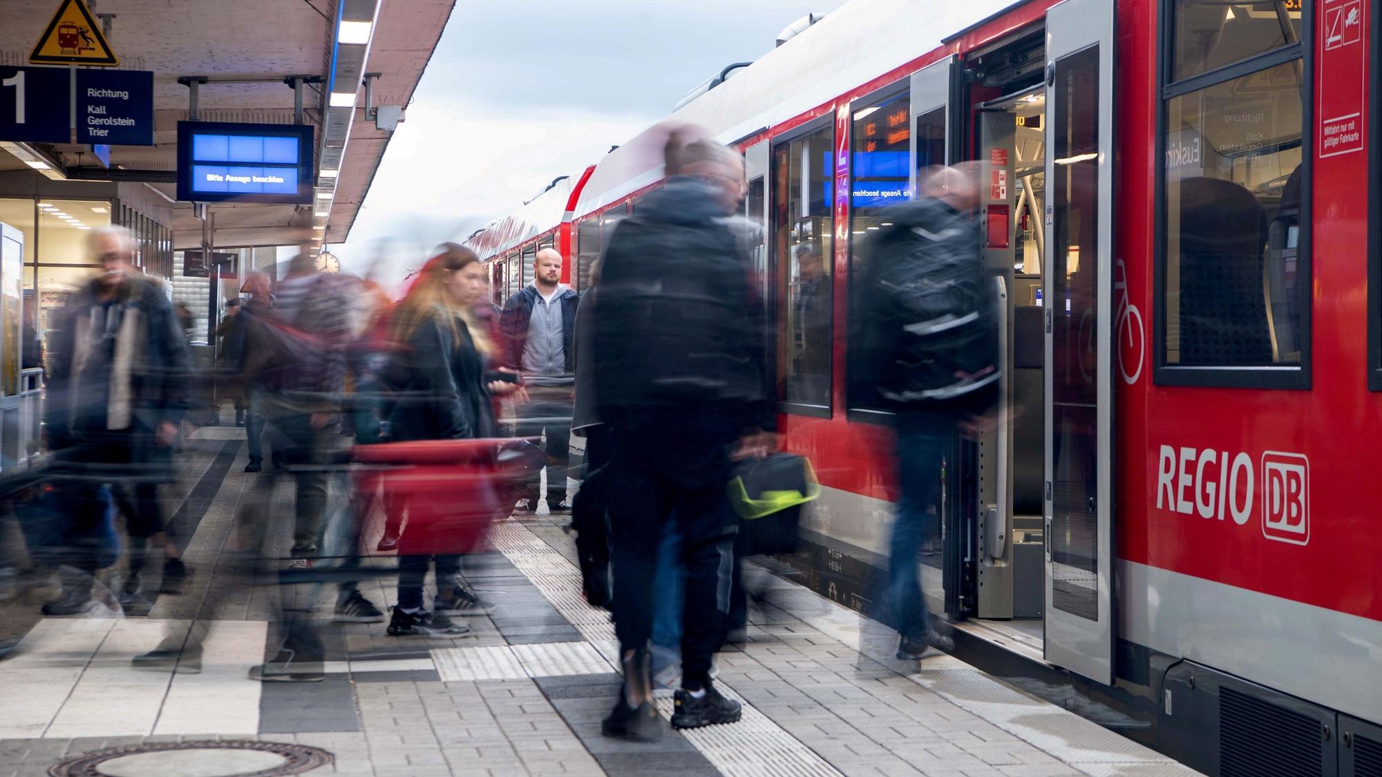 Ein Zug hält im Euskirchener Bahnhof. Die Menschen auf dem Bahnsteig sind verwischt zu sehen.