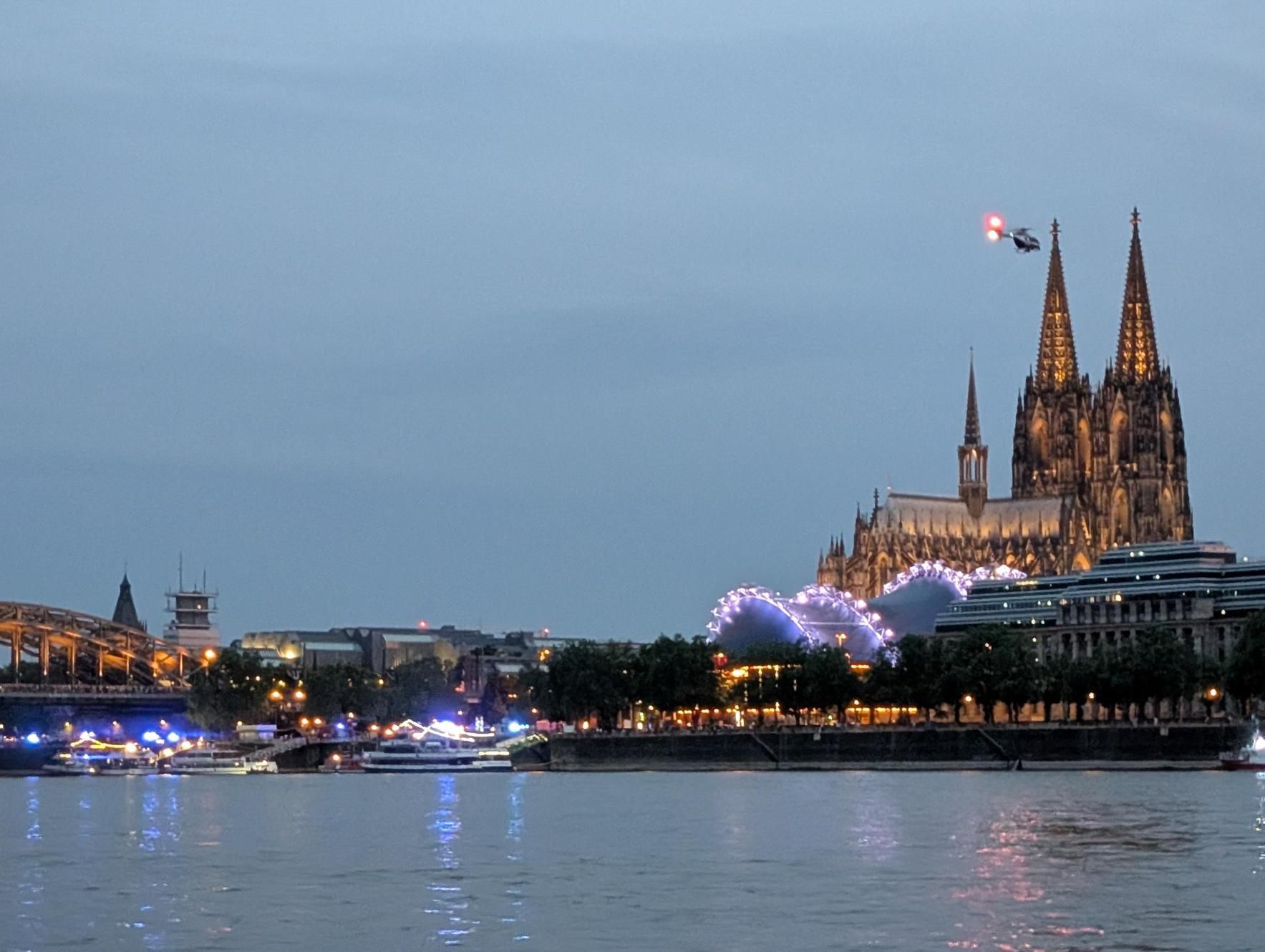 Ein Hubschrauber kreist am Samstagabend in Höhe der Hohenzollernbrücke über dem Rhein.