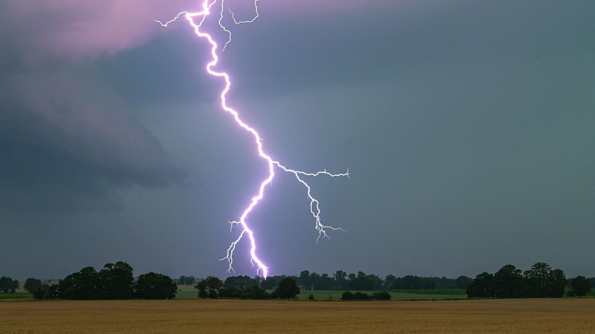 Ein Blitz leuchtet über einer Landschaft auf. (Symbolbild)