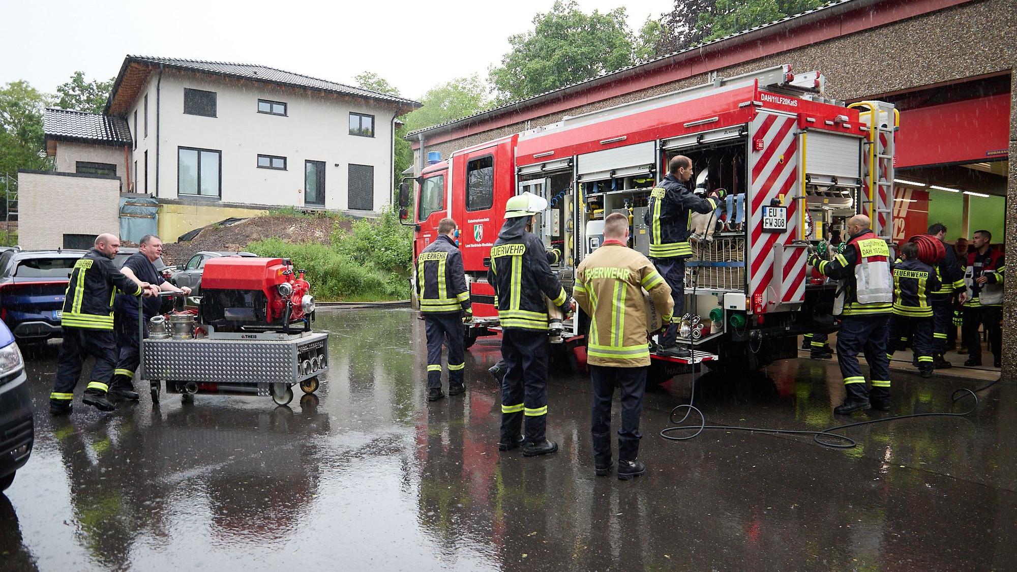 Das Bild zeigt Feuerwehrleute, wie sie ihre Ausrüstung wieder ins Fahrzeug packen.