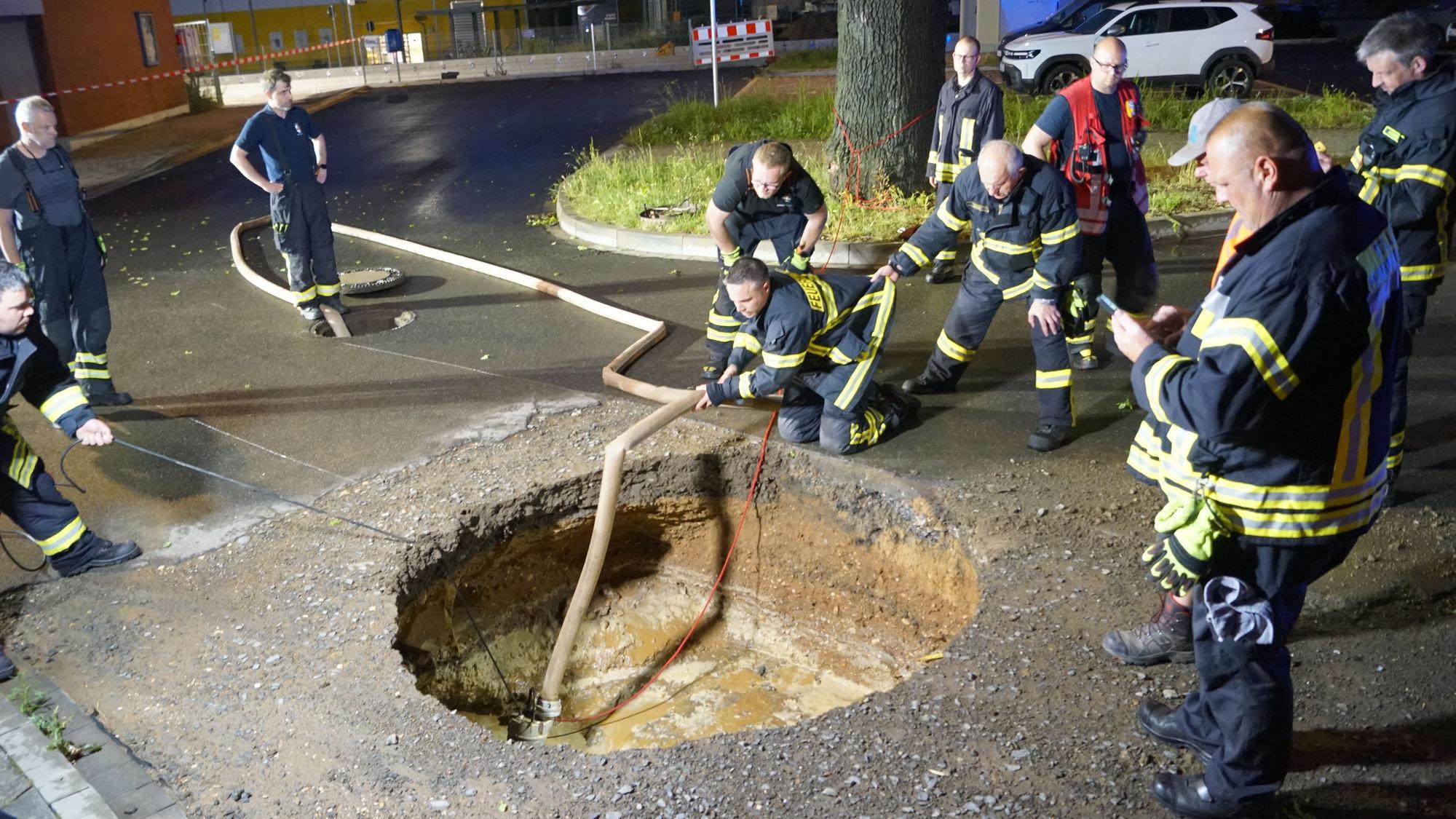 Das Bild zeigt die Zülpicher Feuerwehr, wie sie das kreisrunde Loch leerpumpt.