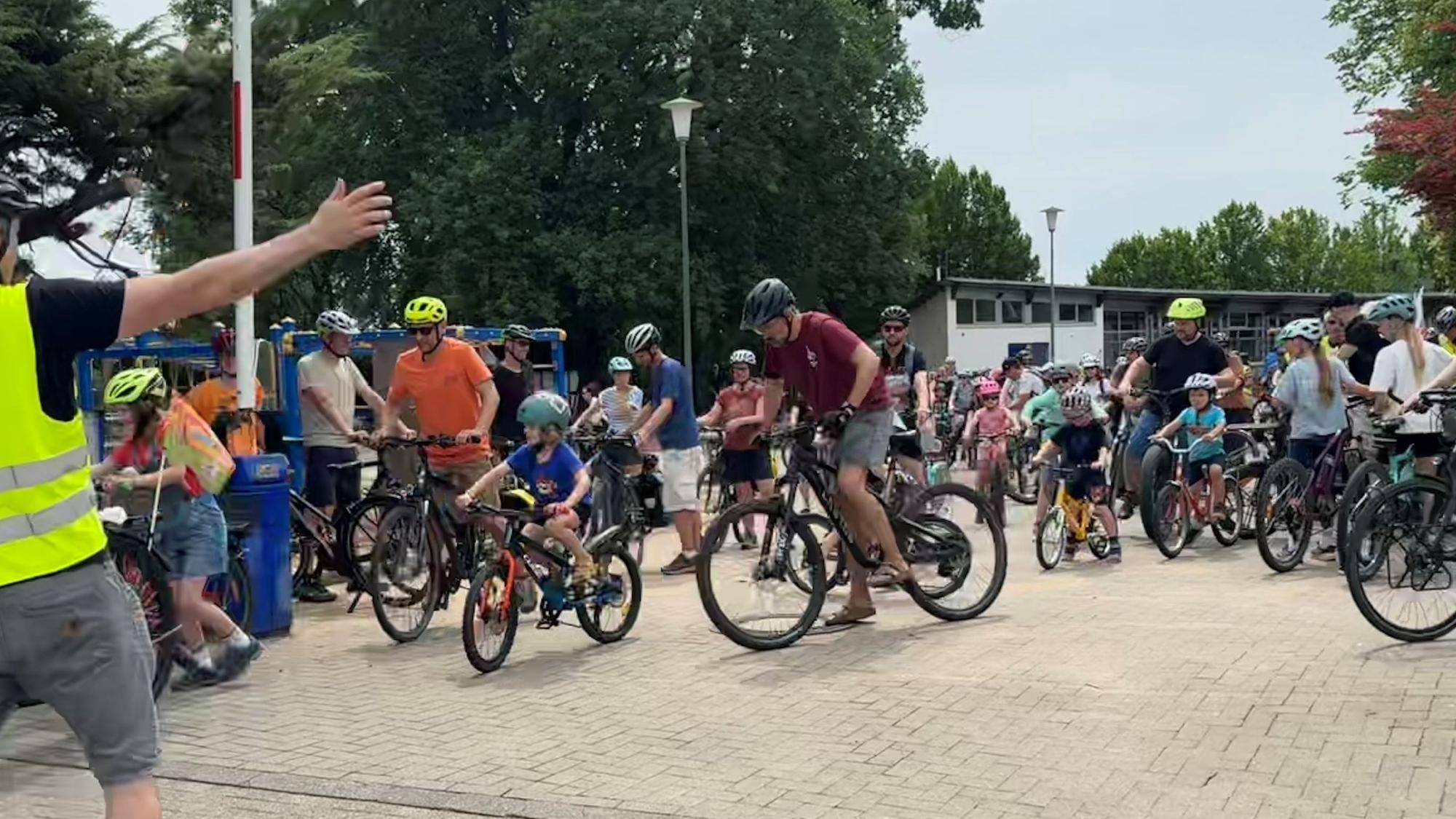 Viele Radfahrer, alle mit Helme. Kinder und Erwachsene