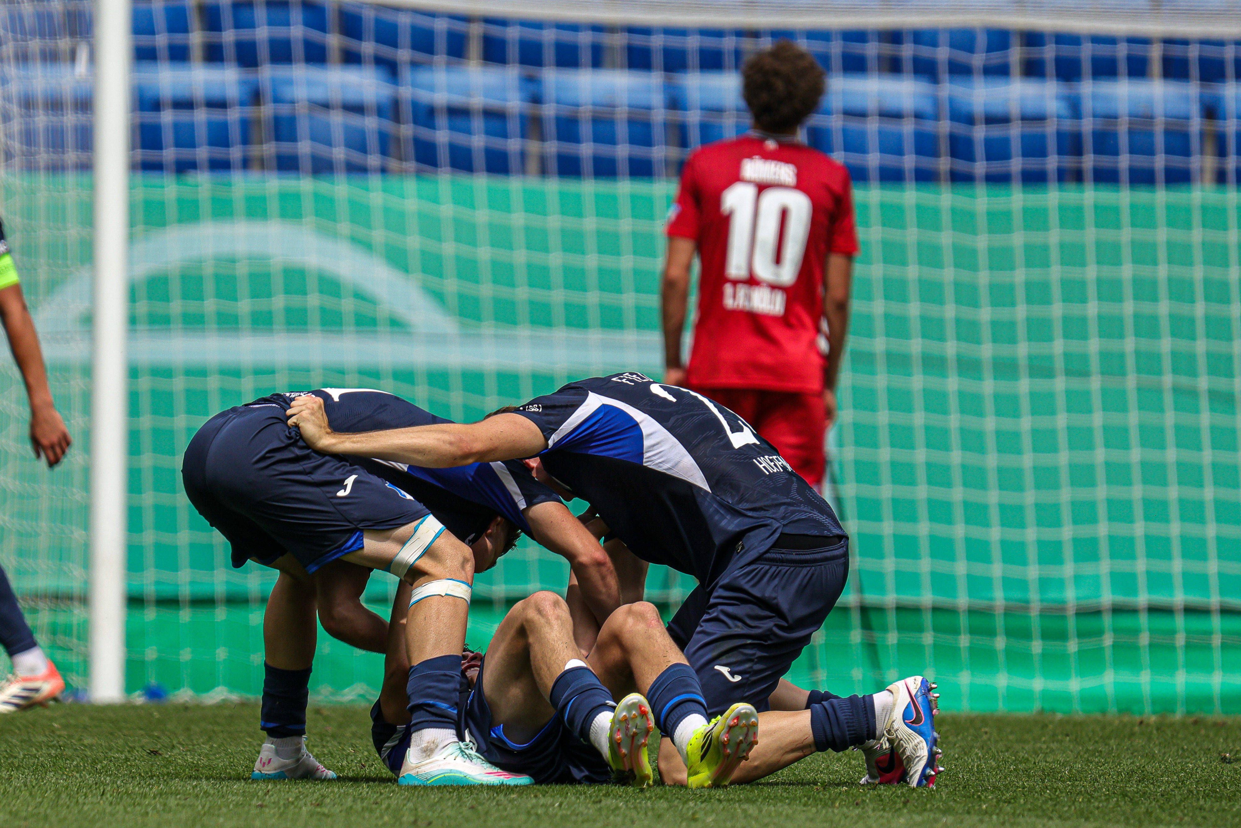 Hoffenheimer Spieler jubeln, im Hintergrund steht ein enttäuschter Kölner.