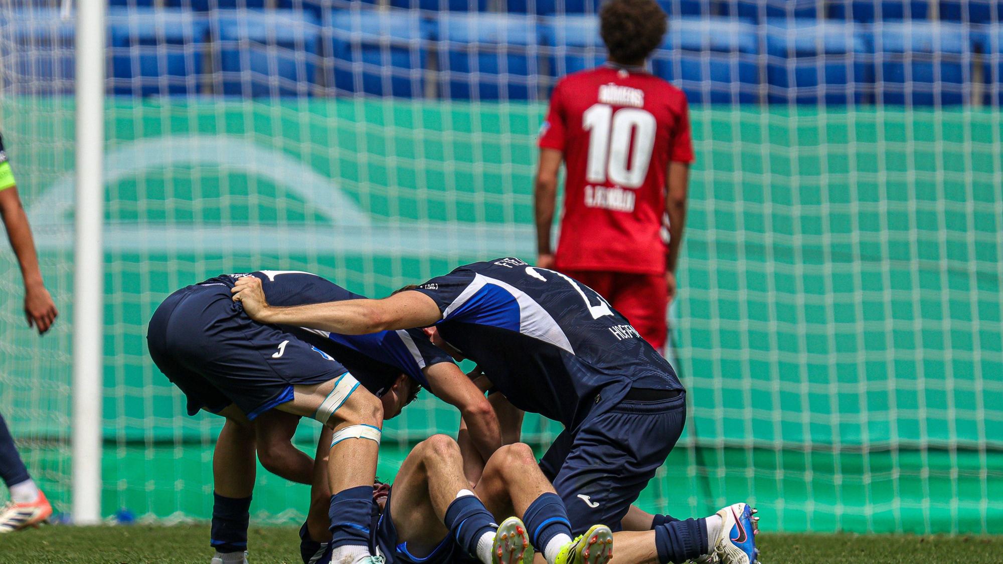 Hoffenheimer Spieler jubeln, im Hintergrund steht ein enttäuschter Kölner.