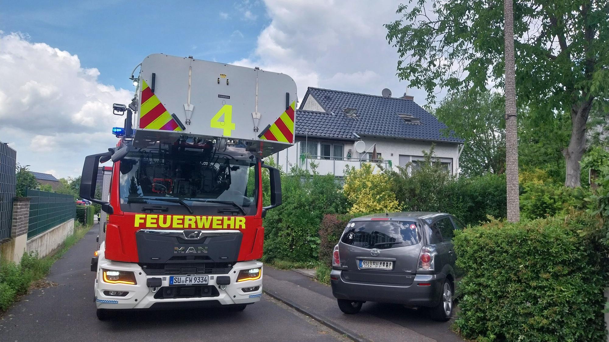 Ein Drehleiterfahrzeug der Feuerwehr steht in einer Wohnstraße.
