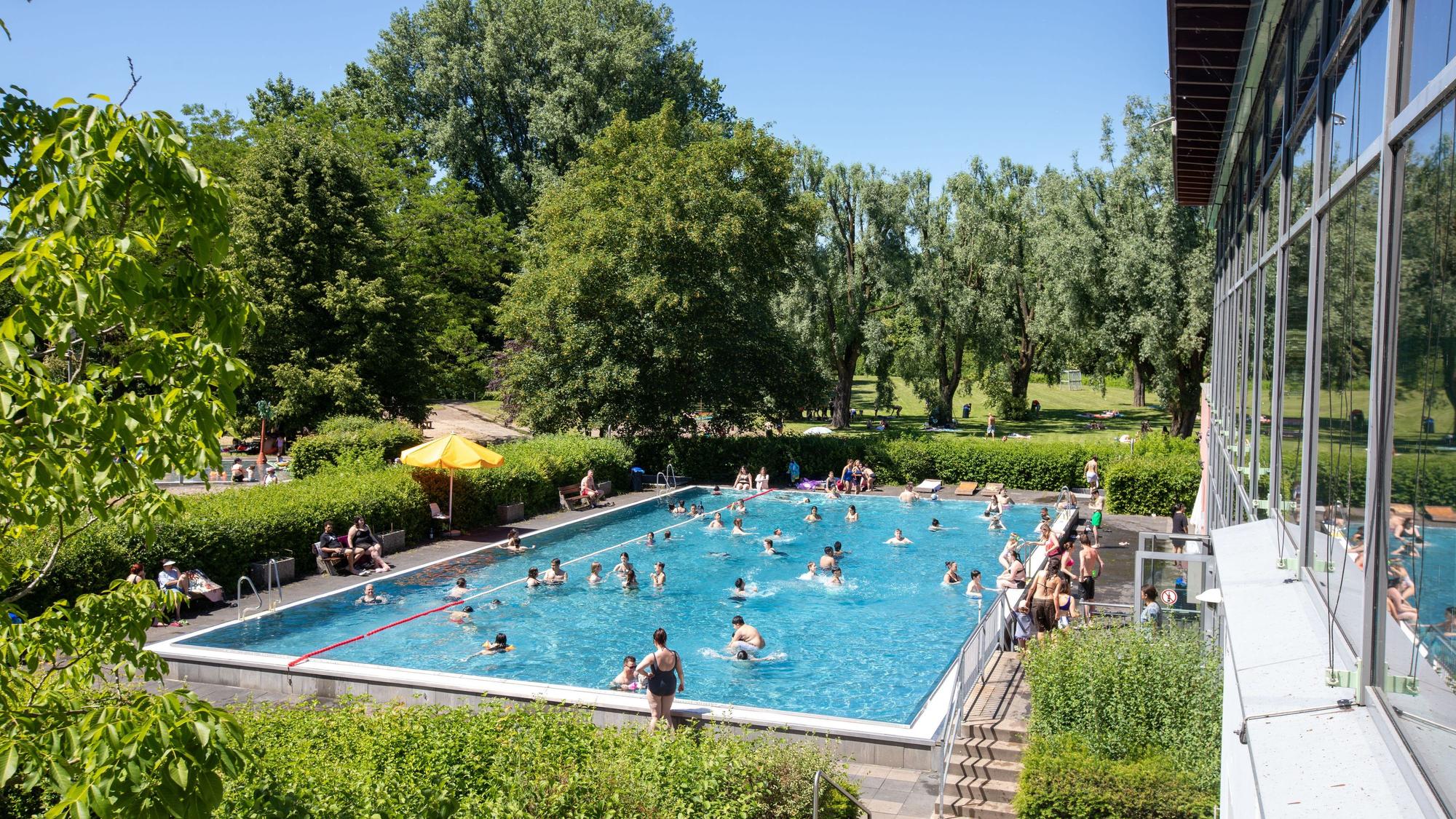 Zu sehen ist der riesige Außenbereich des Zündorfbads, mit Spielmöglichkeiten für Kinder und ein Schwimmerbecken.