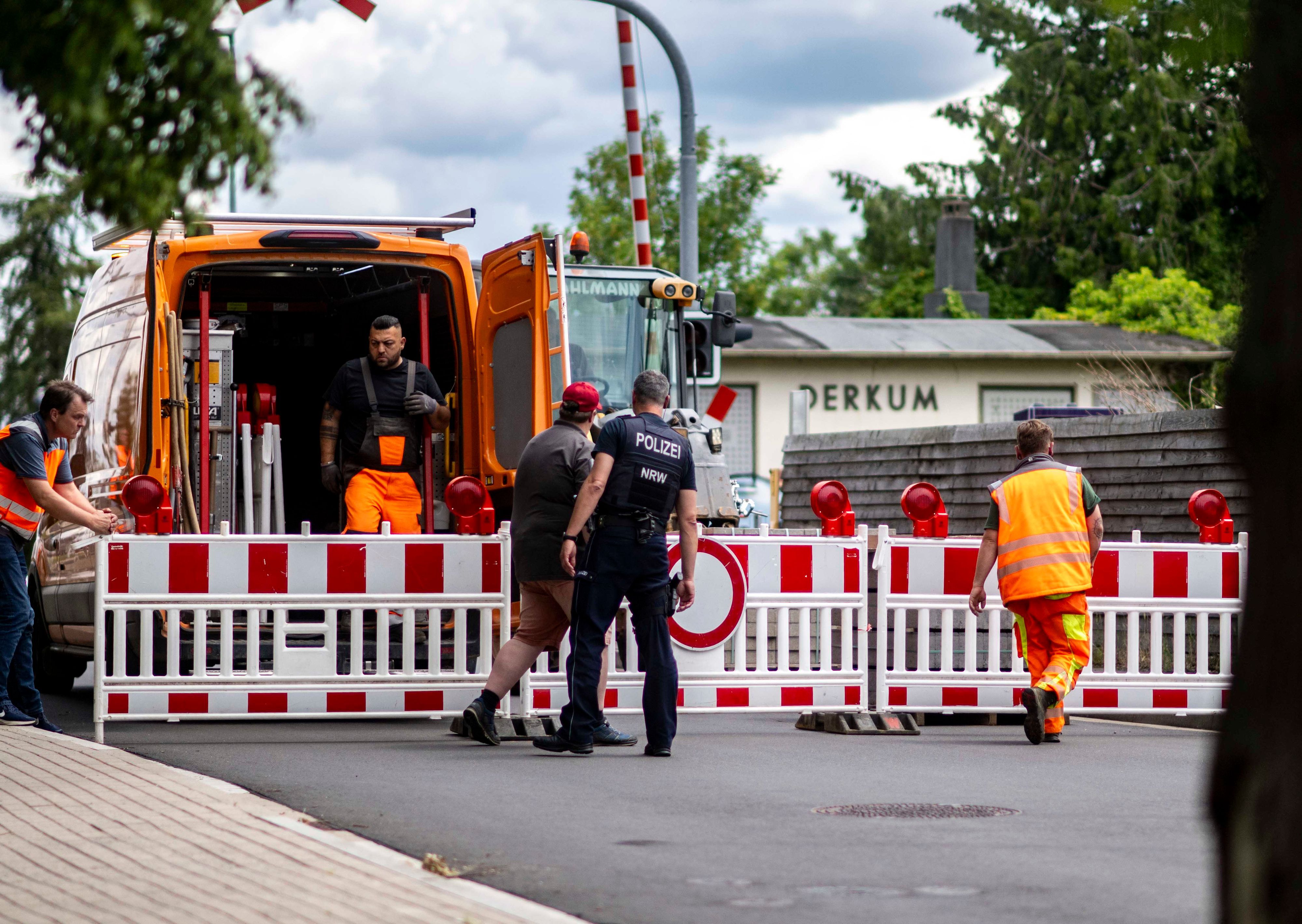 Das Bild zeigt Mitarbeiter des Gemeinde-Bauhofs bei der Sperrung des Bahnübergangs.