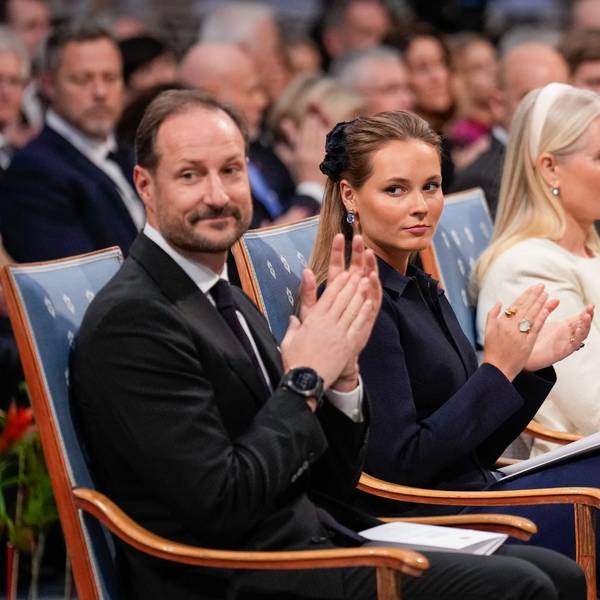 König Haakon und Kronprinzessin Ingrid Alexandra sitzen und klatschen.