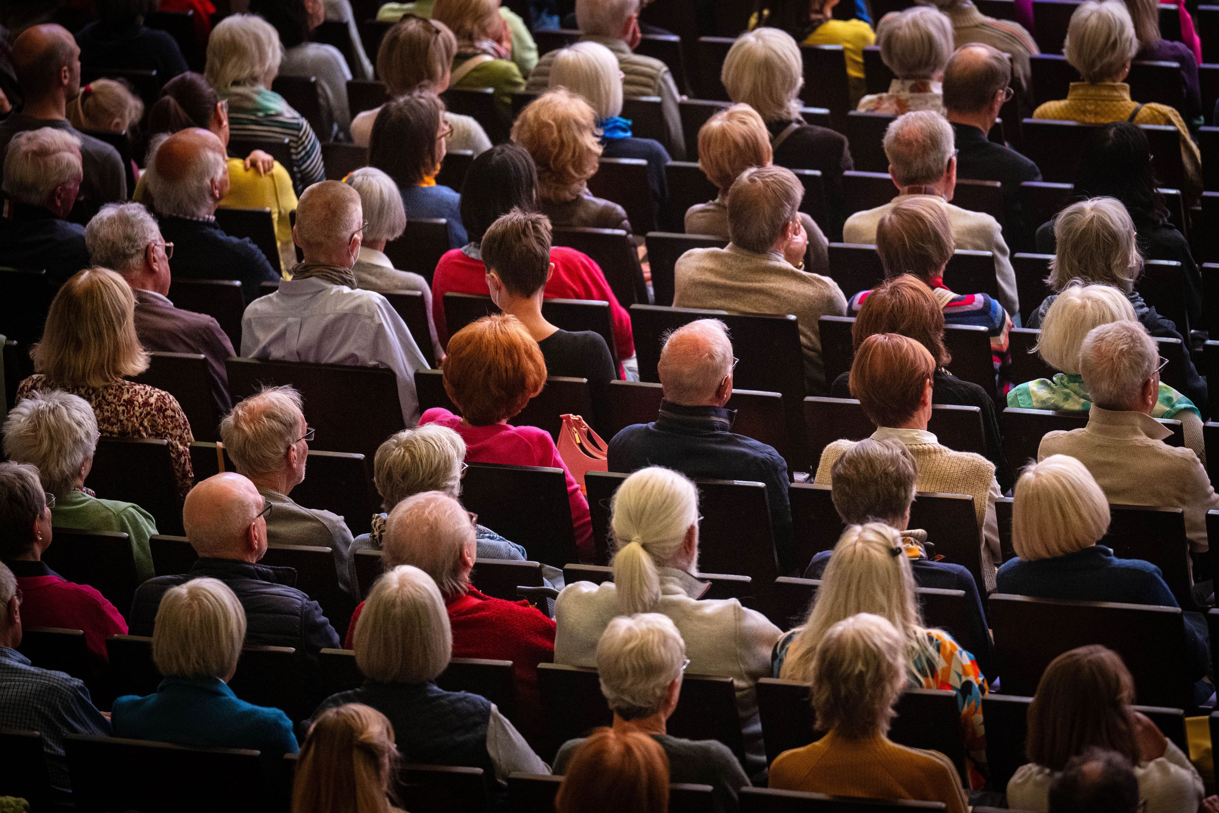 Zuschauer besuchen eine Veranstaltung in einem Konzerthaus.