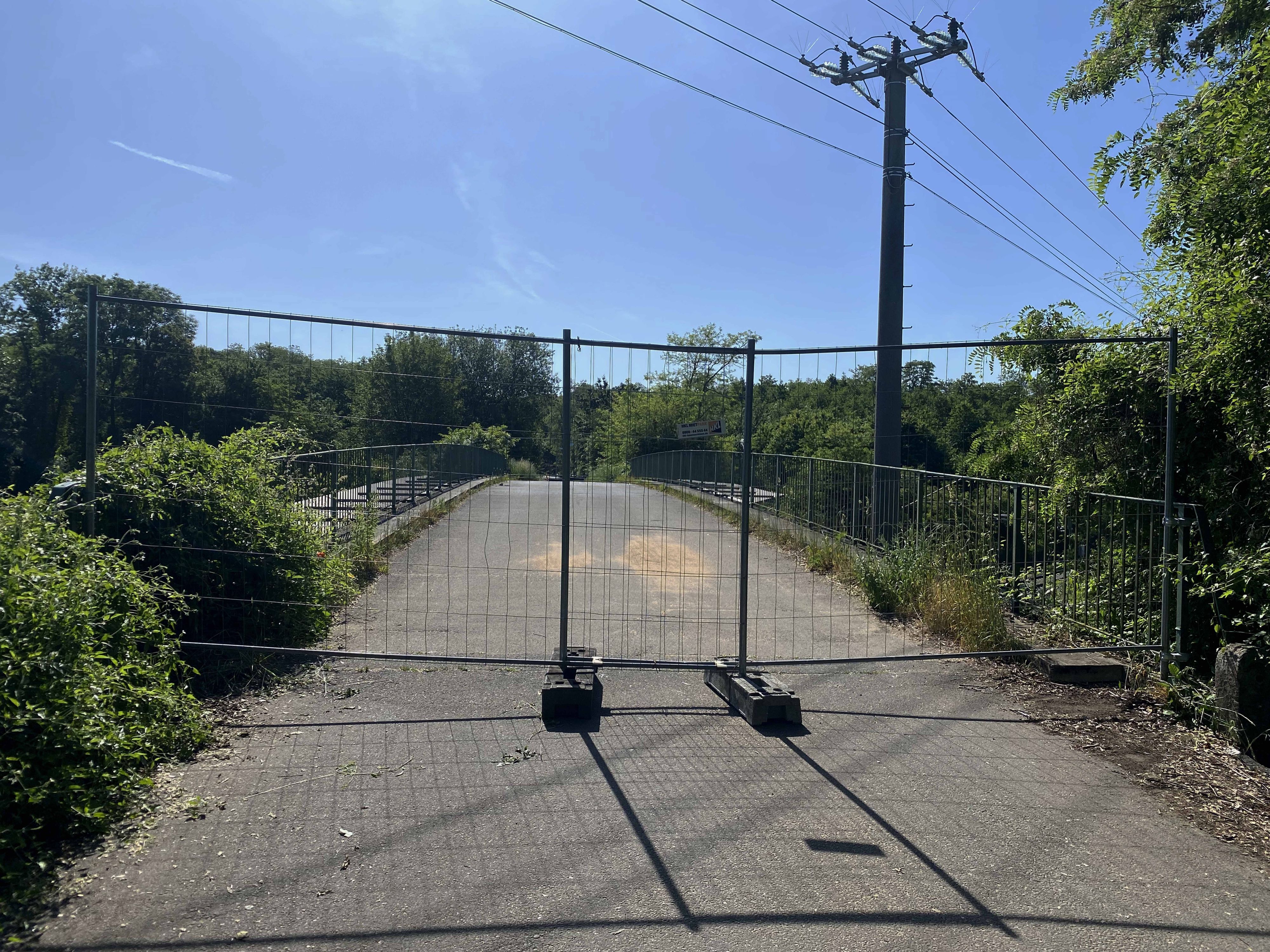 Auf dem Bild ist ein Bauzaun zu sehen, der eine Brücke absperrt.