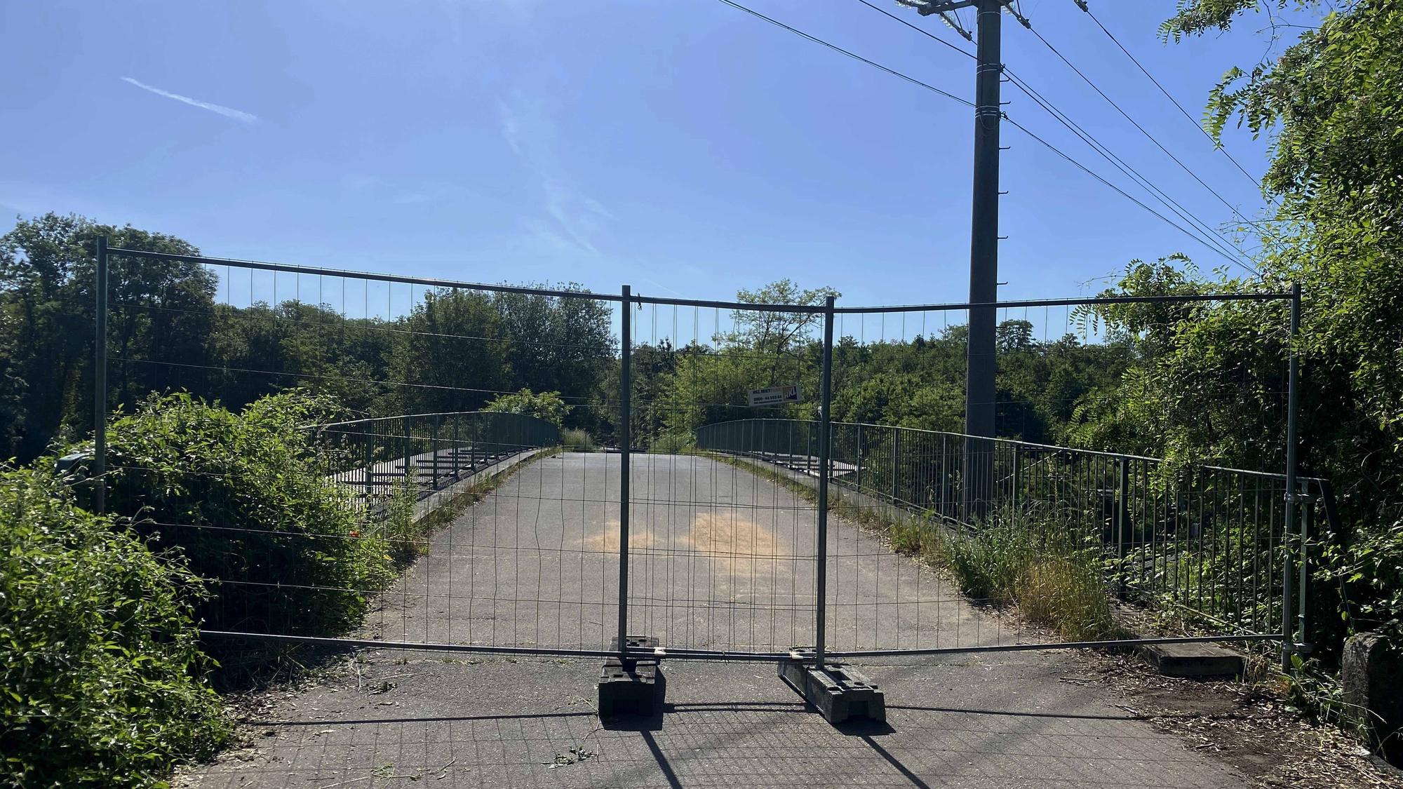 Auf dem Bild ist ein Bauzaun zu sehen, der eine Brücke absperrt.