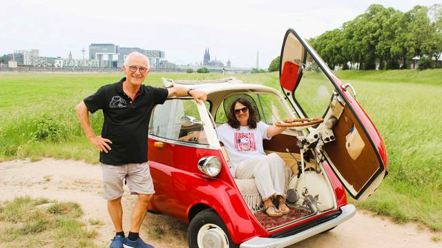 Karin Bernhart und Peter Schmidt mit ihrer Isetta auf den Poller Wiesen, im Hintergrund Rhein und Dom