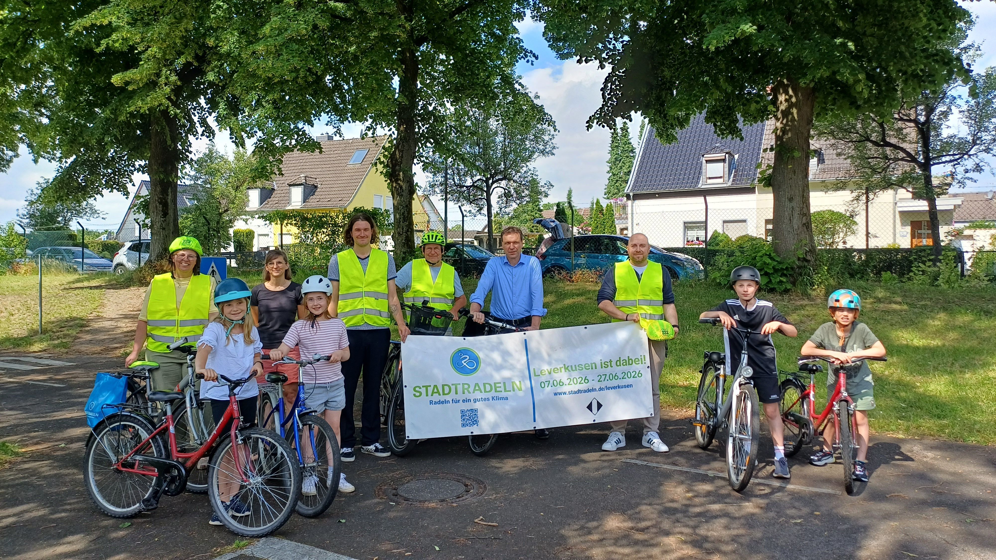 Die stellvertretende Leiterin des Fachbereichs Mobilität und Klimaschutz, Bettina Zimmer (v.l.), Grundschullehrerin Catharina Lehmann, Fahrradbeauftragter Fabian Urh, Wolfgang Dedden vom ADFC, Umweltdezernent Alexander Lünenbach, Malte Müller vom Fachbereich Mobilität und Klimaschutz und vier Kinder aus der Hans-Christian-Andersen-Grundschule bewerben das Stadtradeln.