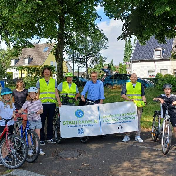 Die stellvertretende Leiterin des Fachbereichs Mobilität und Klimaschutz, Bettina Zimmer (v.l.), Grundschullehrerin Catharina Lehmann, Fahrradbeauftragter Fabian Urh, Wolfgang Dedden vom ADFC, Umweltdezernent Alexander Lünenbach, Malte Müller vom Fachbereich Mobilität und Klimaschutz und vier Kinder aus der Hans-Christian-Andersen-Grundschule bewerben das Stadtradeln.