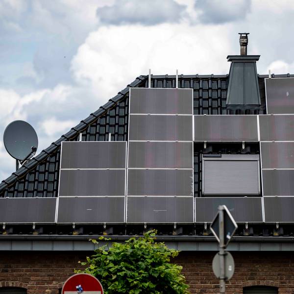 Auf einem Hausdach sind Solarpaneele angebracht.