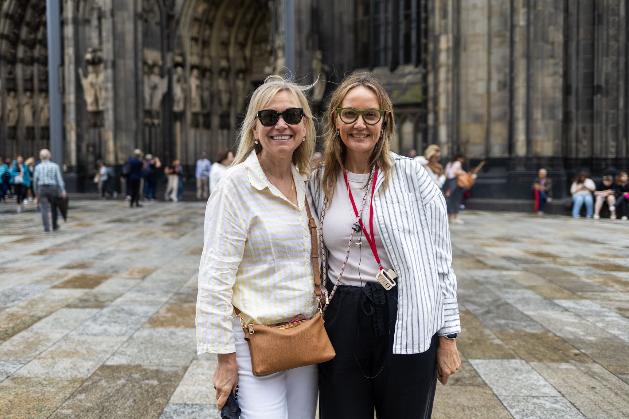 Zwei Frauen in gestreiften Hemden vor dem Kölner Dom.
