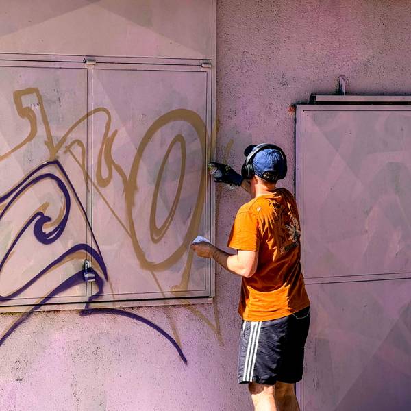 Das Bild zeigt einen Mann, der in der Erftaue eine Wand besprüht.
