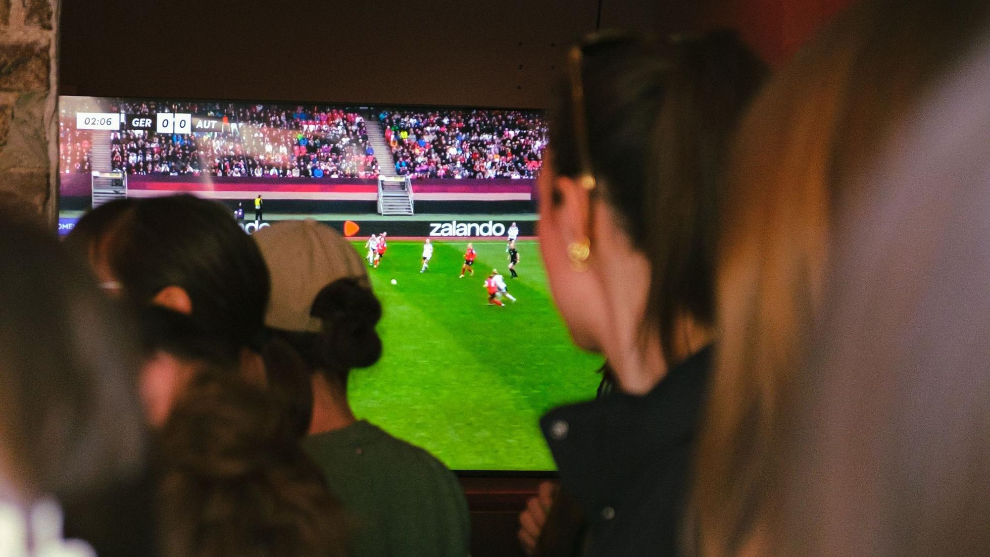 Frauen schauen gemeinsam Frauenfußball.