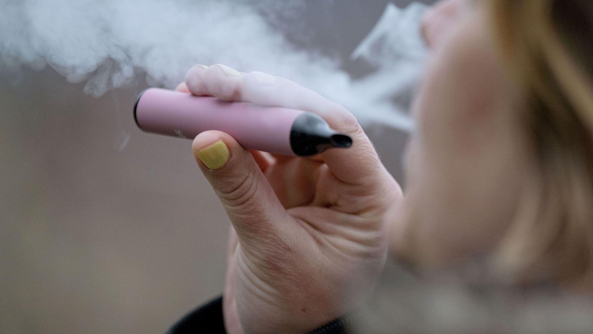 Eine Frau raucht eine elektronische Zigarette (Vape): Immer wieder entstehen Brände durch falsch entsorgte Akkus.