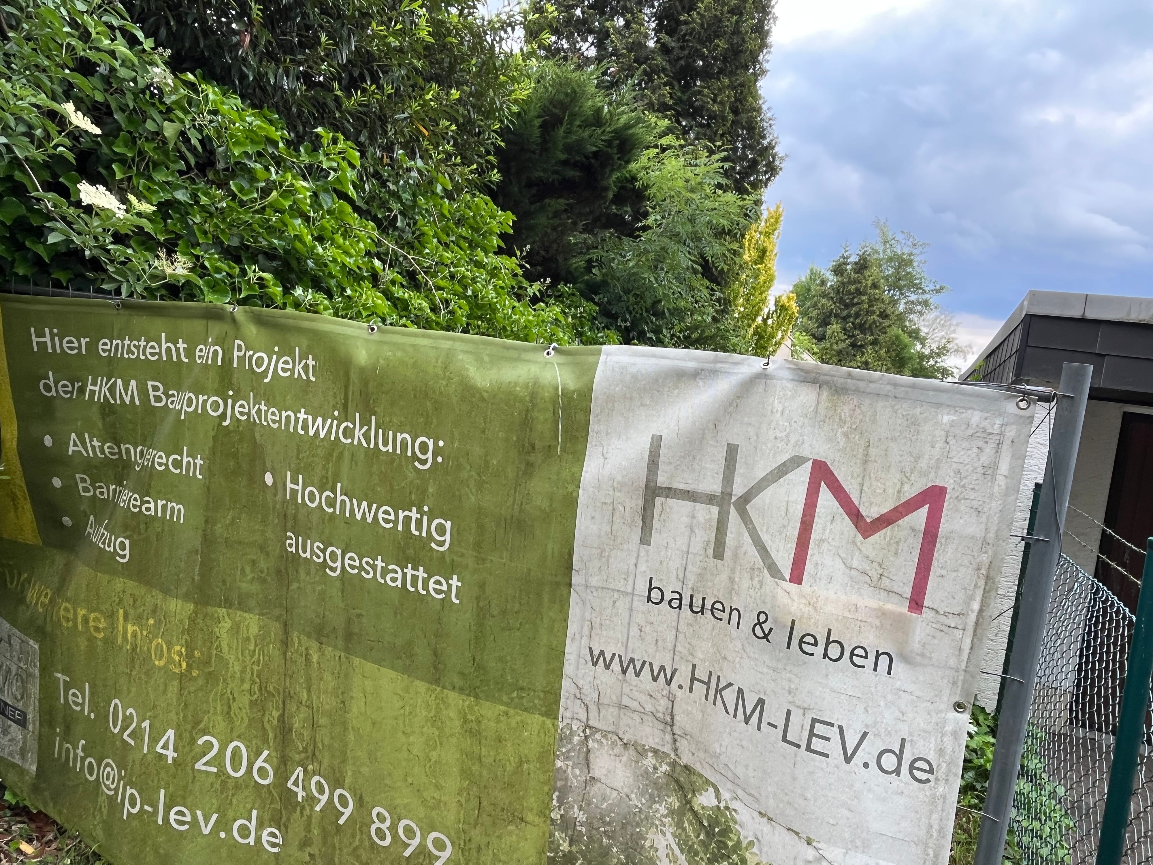 Banner der Firma HKM an einem Zaun am Grünen Weg.