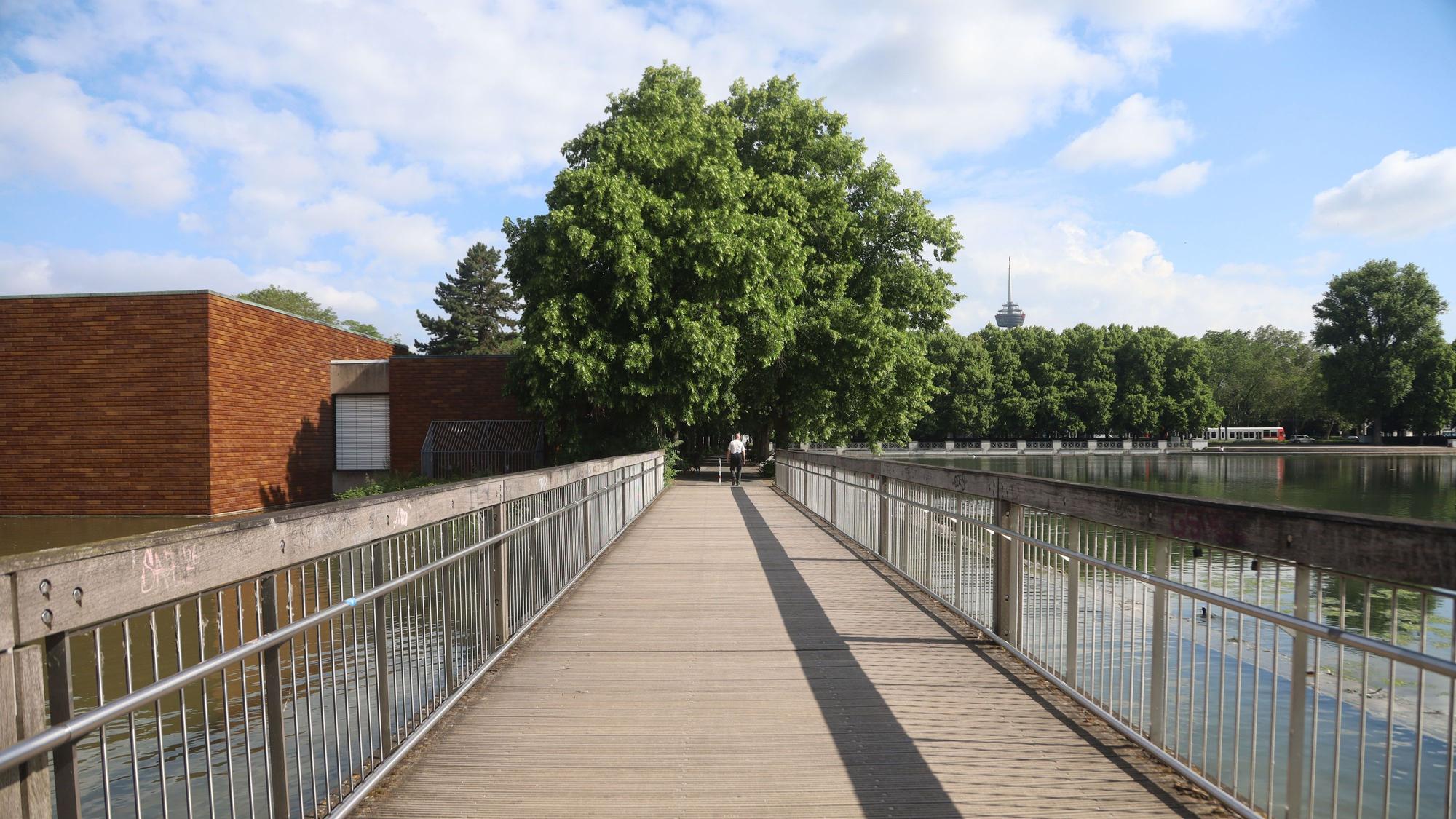 01.06.2026, Köln: Die kleine Holzbrücke zwischen Aachener Weiher und Ostasiatischem Museum wurde 2014 fertiggestellt. Zuvor stand hier ein Brückenbauwerk, das Ende der 1990er-Jahre Teil eines Korruptionsskandals war. Foto: Arton Krasniqi