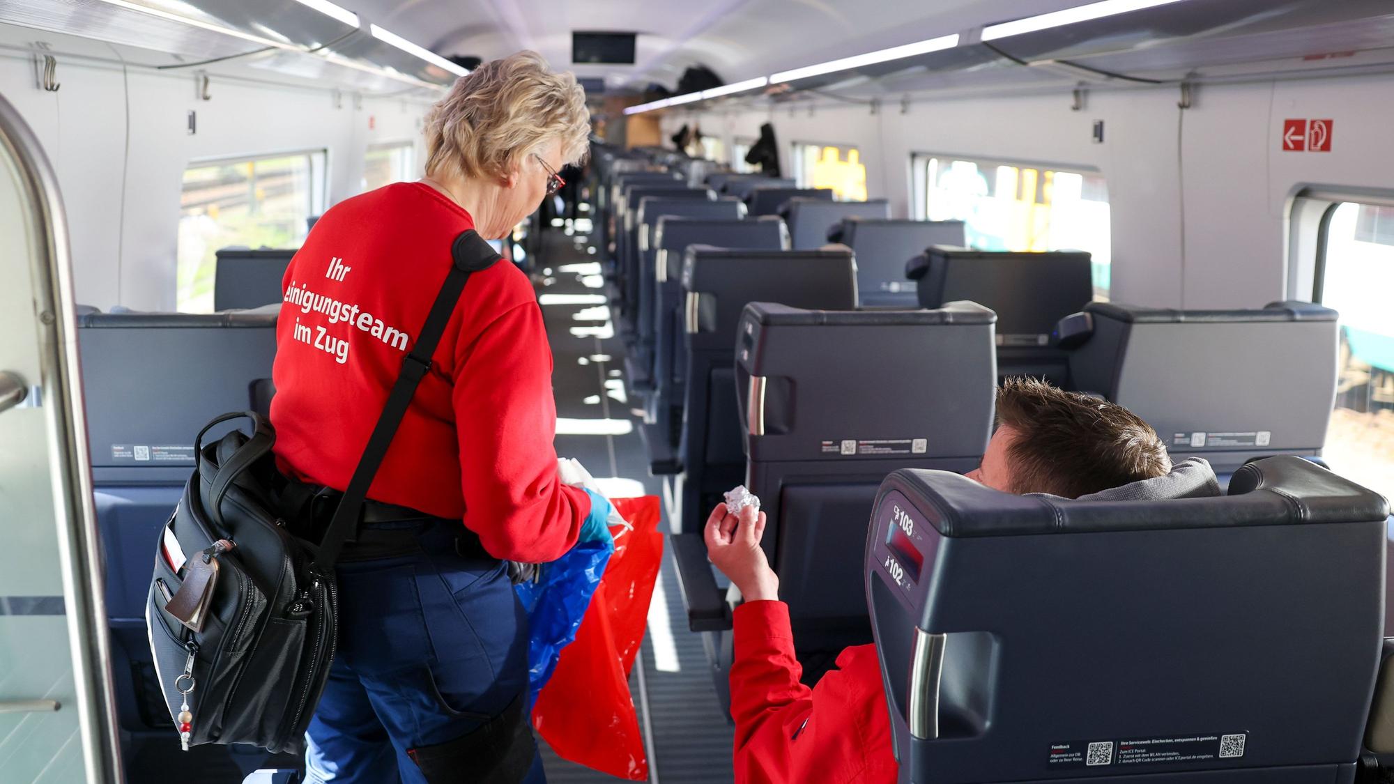 28.04.2026, Sachsen, Leipzig: Sandra Lux, «Unterwegsreinigerin», nimmt den Abfall von Passagieren in einem ICE-4 auf der Fahrt von Leipzig nach Hamburg mit. Rund 400 ICE sind täglich bundesweit auf den Schienen unterwegs. Rechnerisch befördert die Bahn im Fernverkehr mehr als 370.000 Reisende täglich. Damit dabei die Züge sauber bleiben, hat die Bahn ein Sofortprogramm für mehr Komfort im Fernverkehr aufgelegt. Die Zahl der «Unterwegsreiniger» stieg von 110 auf 220. (zu dpa: «Duftöl für mehr Komfort - Wie die Bahn Züge sauber hält») Foto: Jan Woitas/dpa +++ dpa-Bildfunk +++