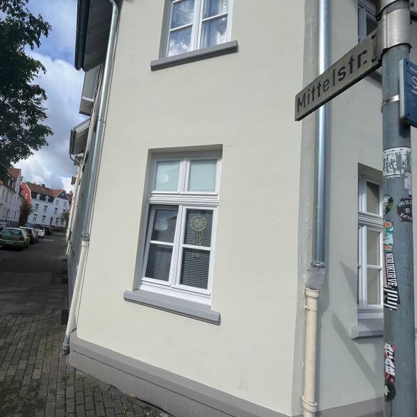 Ein Haus an einer Straßenecke mit Schildern