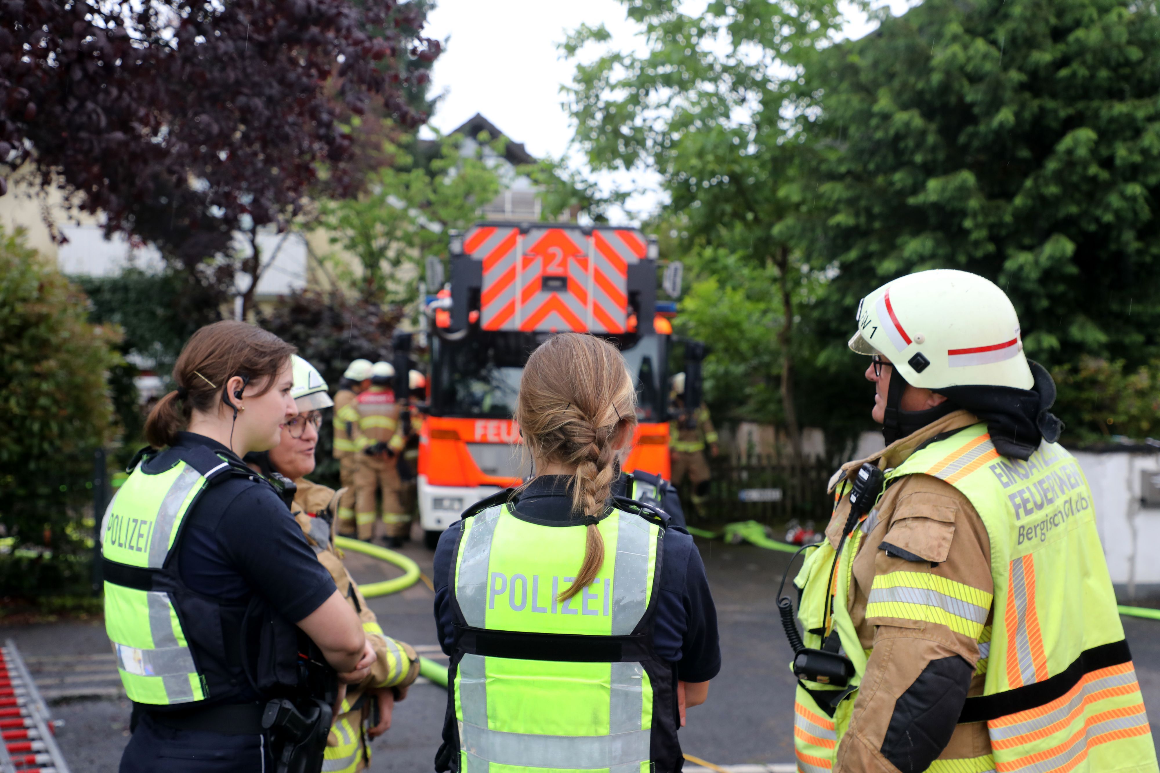 Feuerwehreinsatzleiter Stefan Mertens und Polizeibeamtinnen am Einsatzort in Alt-Refrath.