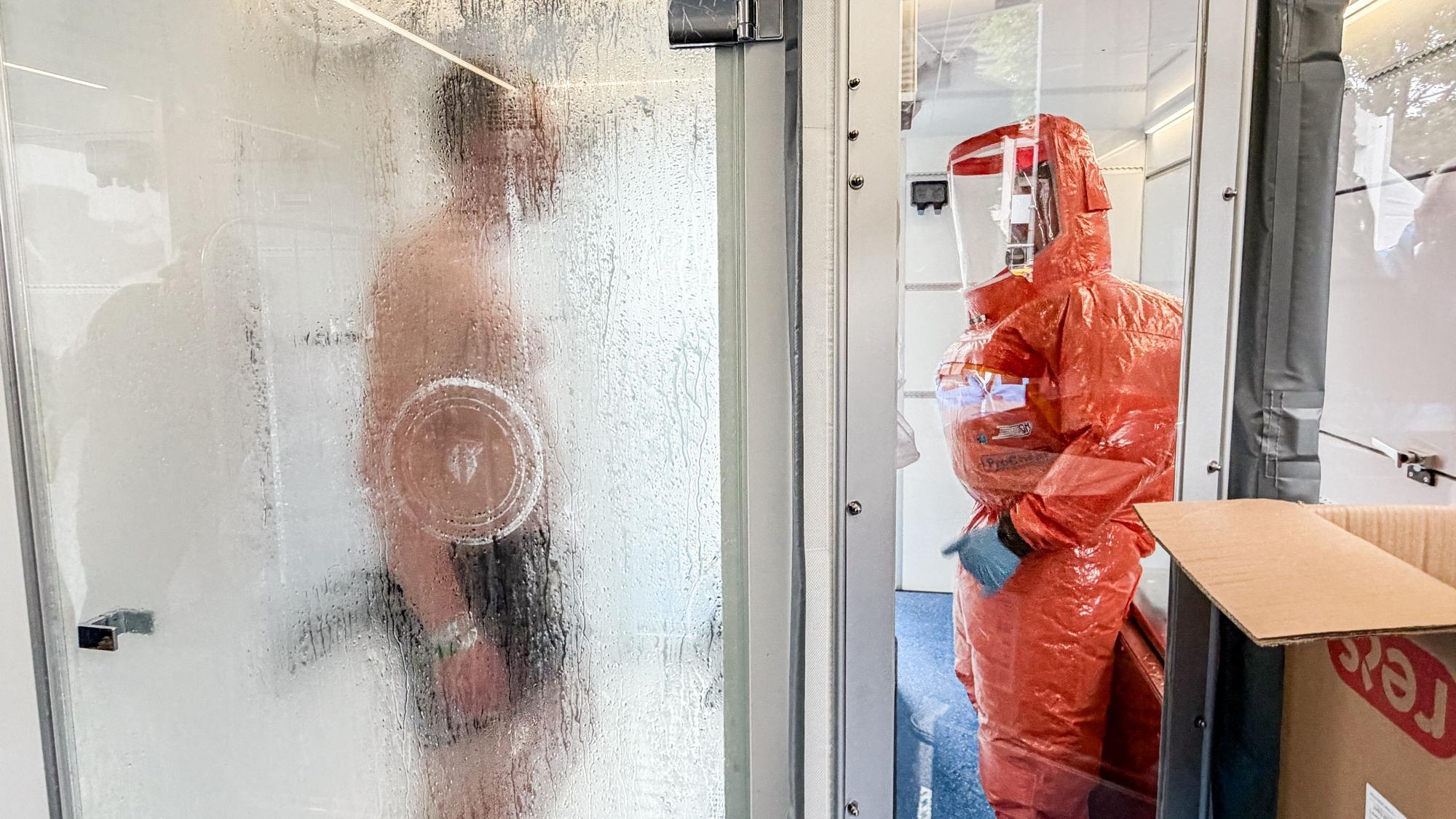 Ein Statist wird während der Übung in einer Dusche dekontaminiert.