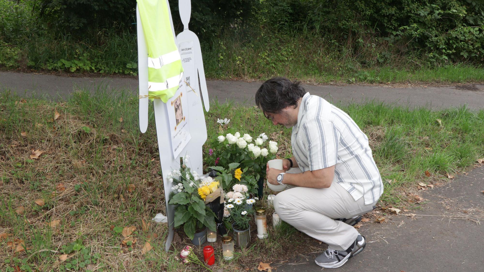 Der Vater der durch den Unfall am 4. Juni 2025 tödlich verletzten Avin stellt Blumen und Kerzen an der Gedenkstelle an der Frechener Straße auf