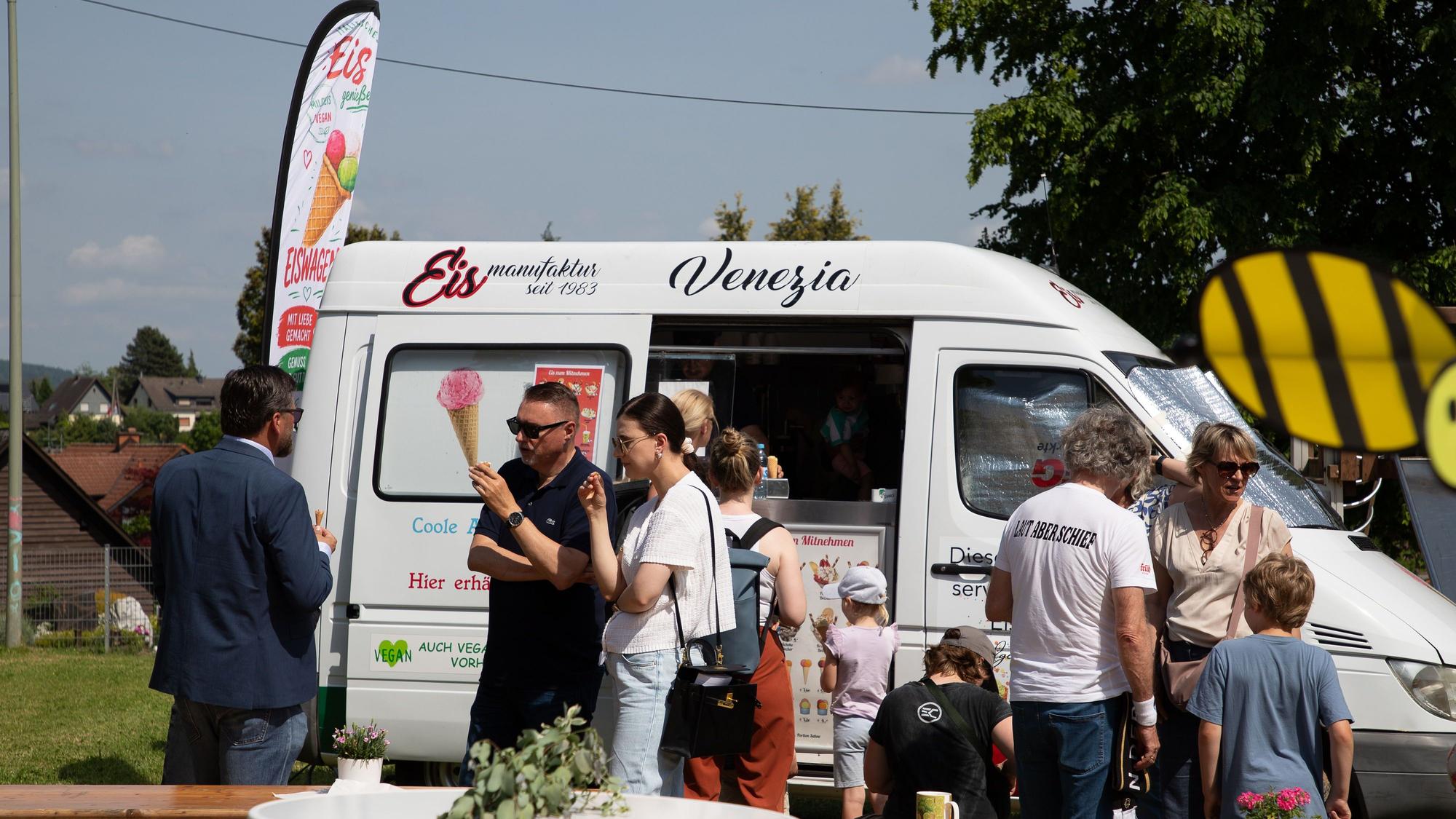 Vor einem weißen Eiswagen stehen Besucher des Spielplatzes und Bürgermeister Michael Eyer.