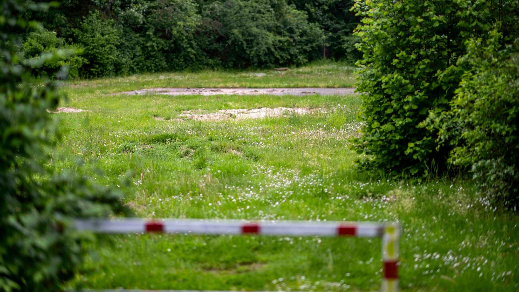 Das Bild zeigt eine Wiese umringt von Bäumen, auf der einst ein Spielplatz stand.