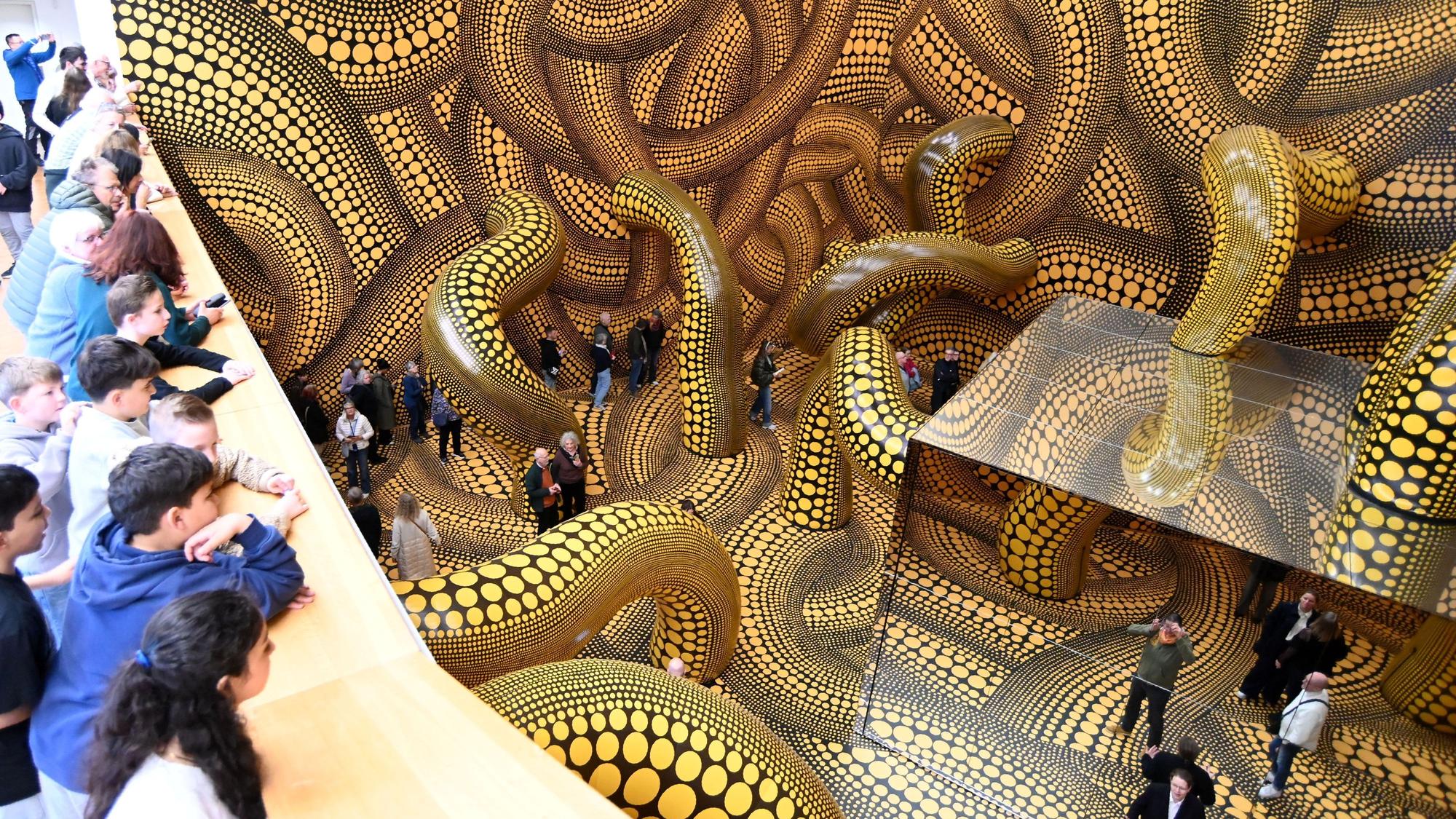 14.04.2026 Köln. Beate Wickenden und Ralph Peters sind die 100.000 Besucher in der Ausstellung Yayoi Kusama im Museum Ludwig. OB Torsten Burmester gratuliert. Foto: Alexander Schwaiger