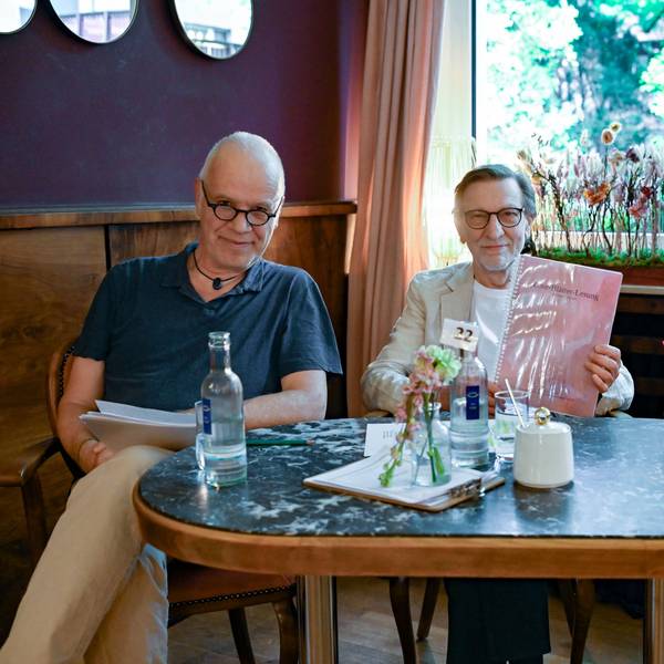 Drei Männer sitzen mit ihren Texten an einem Tisch im Café Osterspey in Sülz.