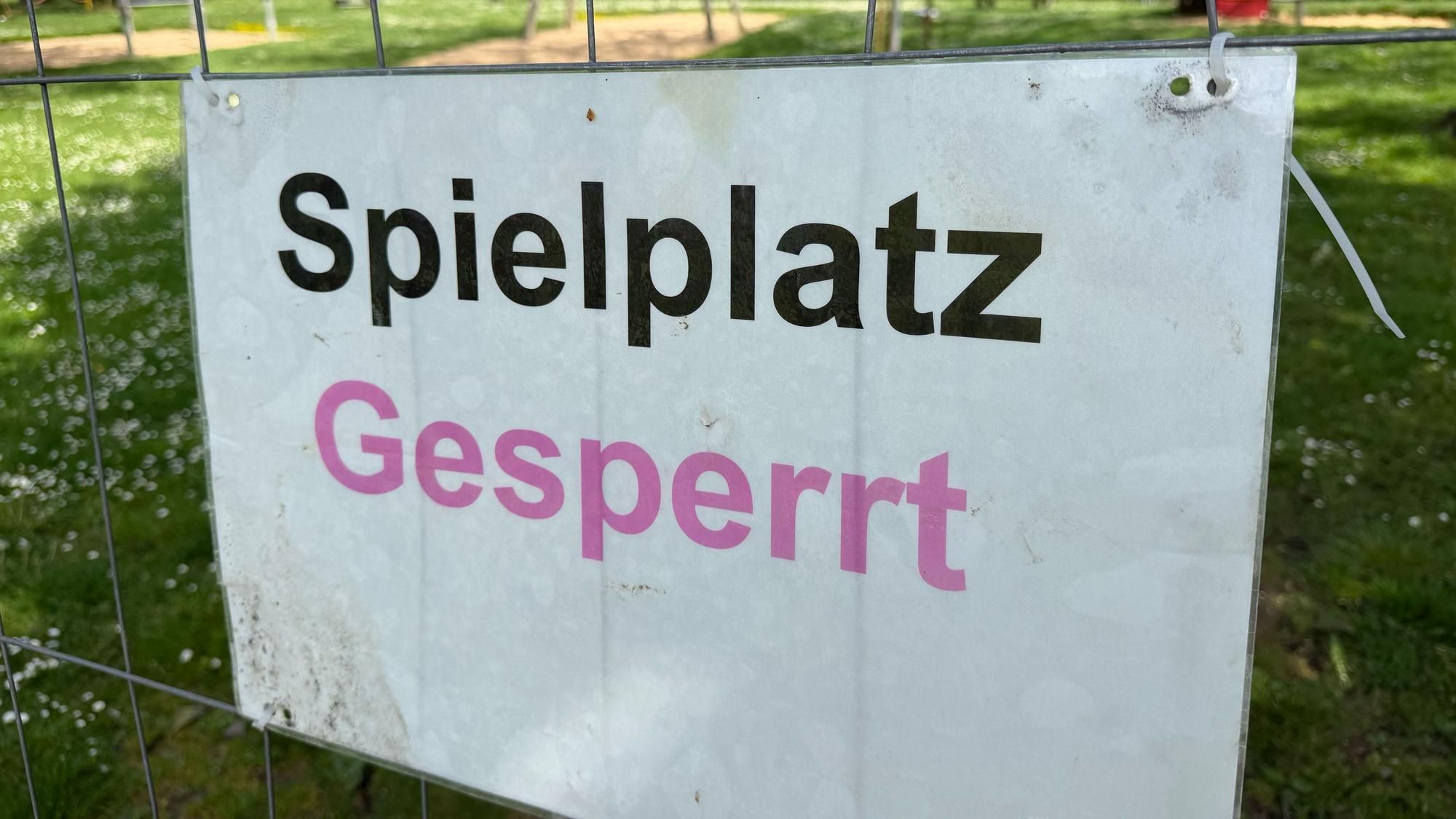 Ein Schild mit der Aufschrift „Spielplatz gesperrt“ hängt an einem Bauzaun.