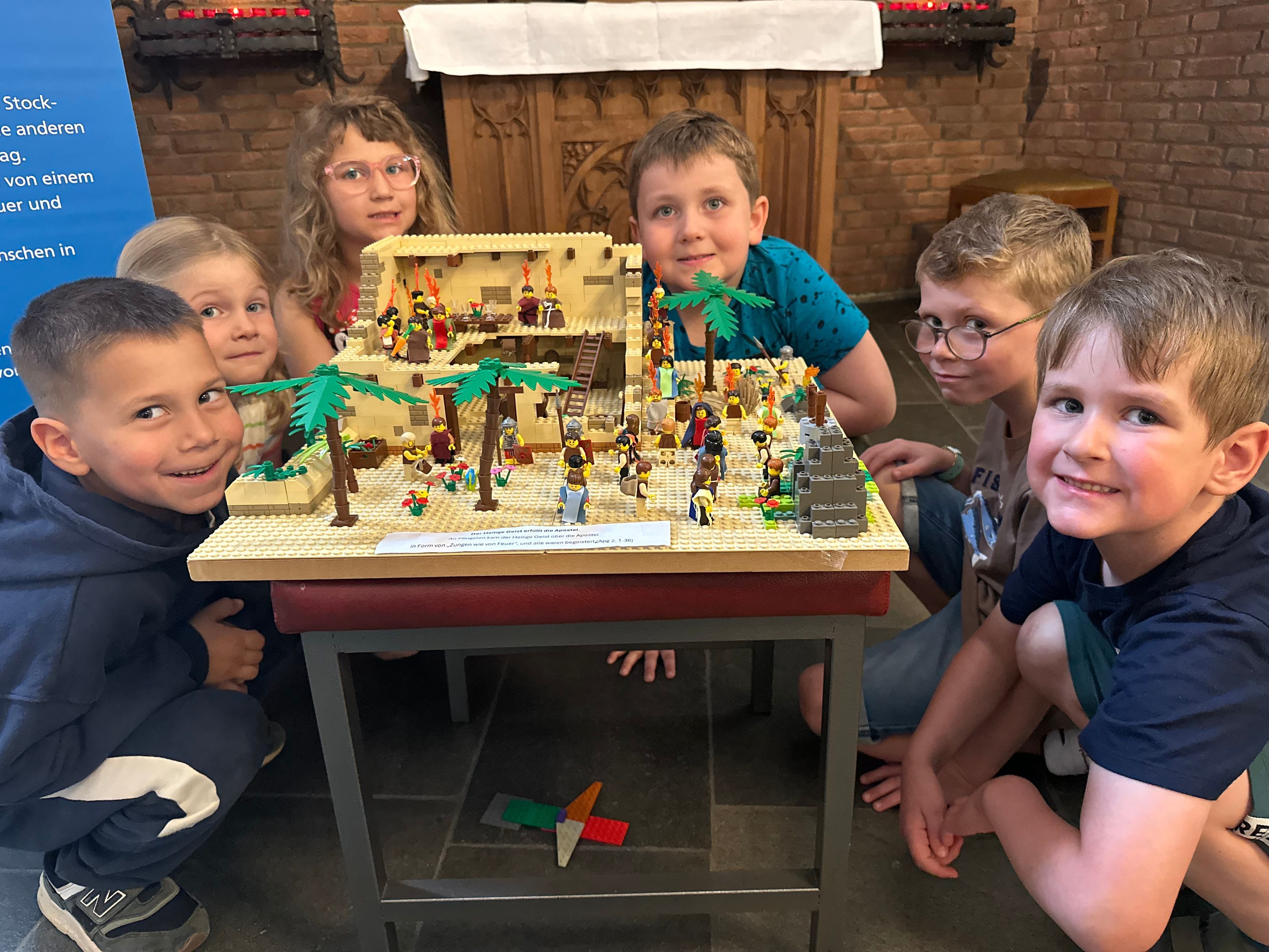 Ganz nah Anschauen erwünscht: Kindergartenkinder an der Station der Ausstellung, die Pfingsten darstellt.