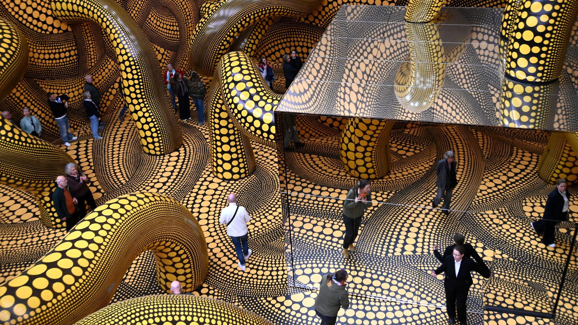 14.04.2026 Köln. Beate Wickenden und Ralph Peters sind die 100.000 Besucher in der Ausstellung Yayoi Kusama im Museum Ludwig. OB Torsten Burmester gratuliert. Foto: Alexander Schwaiger