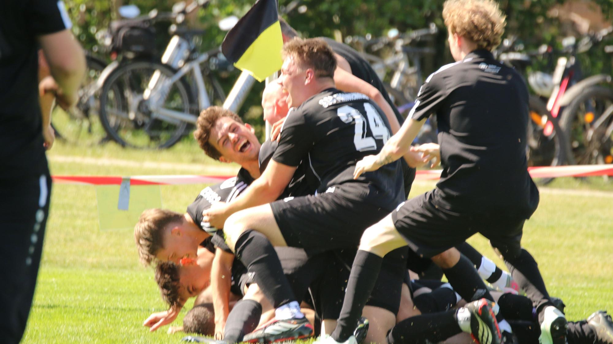Spieler des SSC Firmenich bejubeln übereinander die 2:1-Führung.