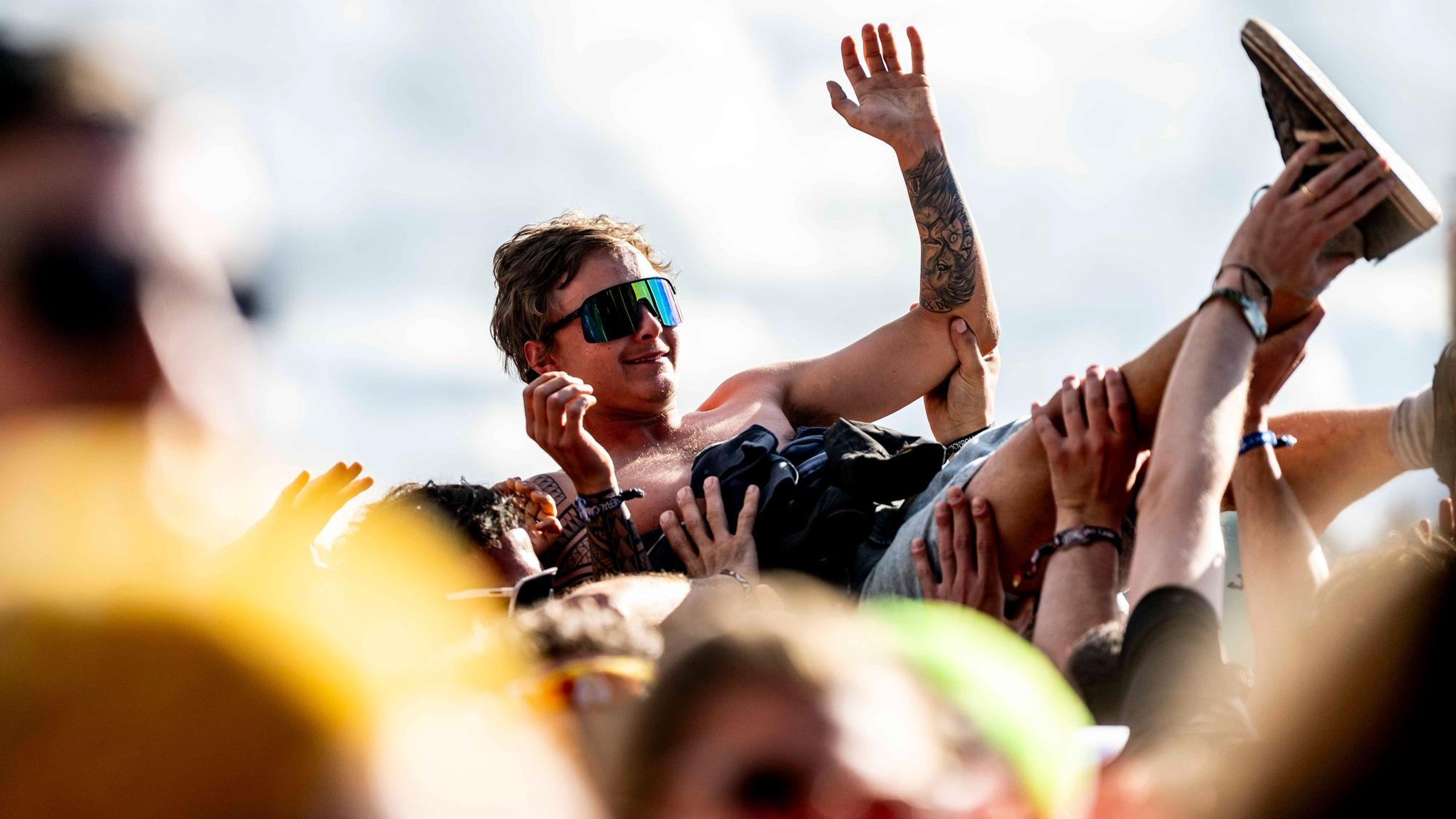 Beim Crowdsurfing wird ein Fan beim Festival Rock am Ring von anderen auf Händen über die Menge getragen.