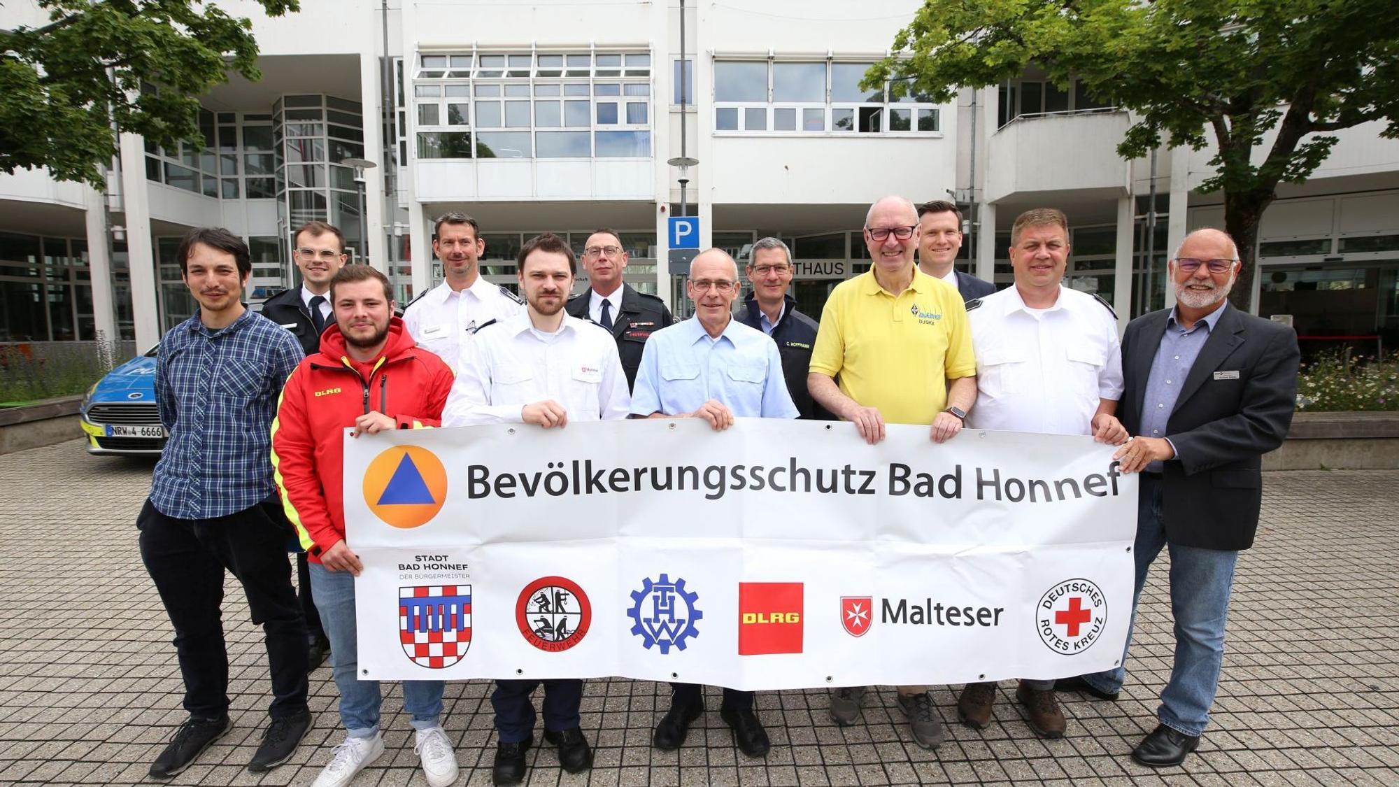 Eine Gruppe von Männern mit einem Transparent mit der Aufschrift „Bevölkerungsschutz Bad Honnef“.