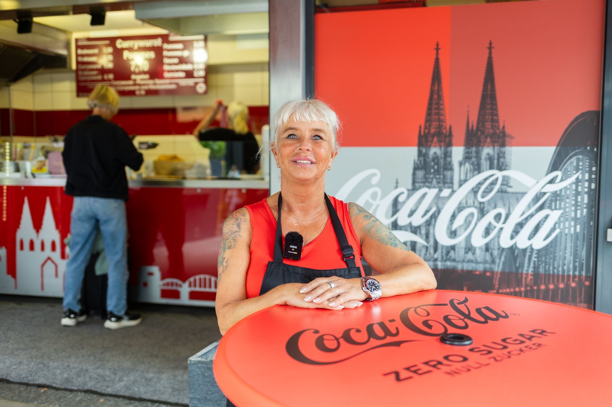 Eine Frau steht vor einer Imbissbude.