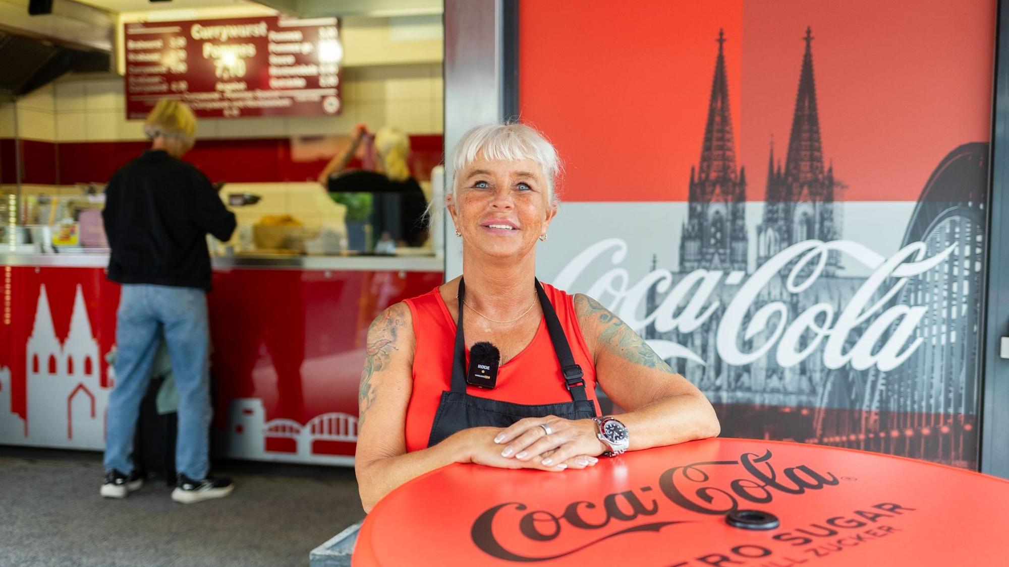 Eine Frau steht vor einer Imbissbude.